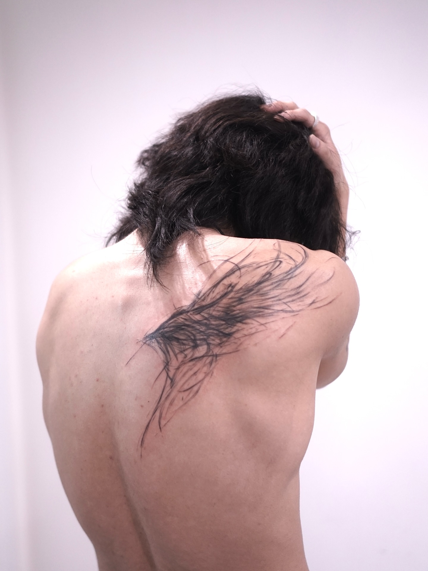 Feather black and grey tattoo on the shoulder by Young one 영원