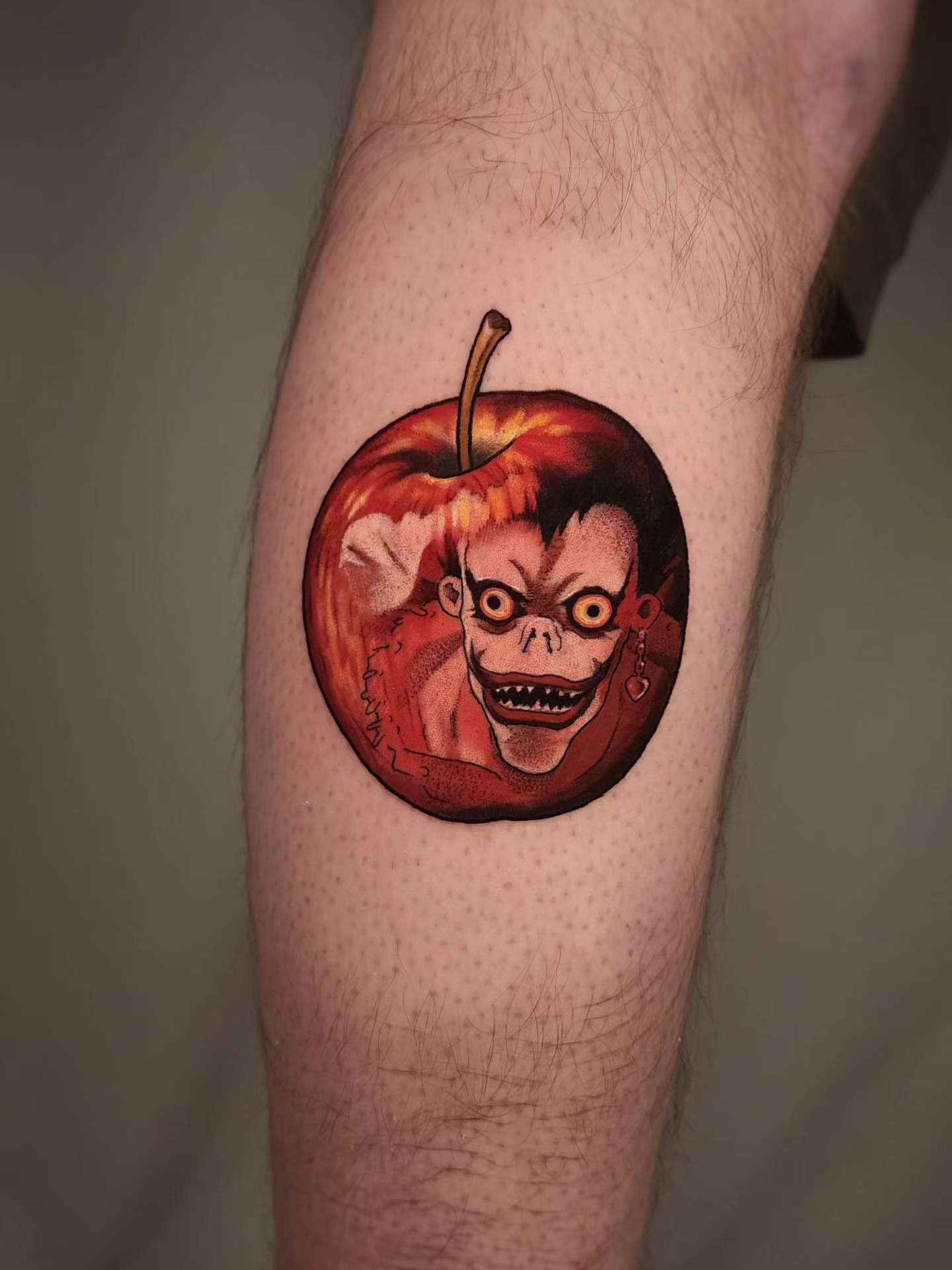 Apple with skull dark realism tattoo on the forearm by Whitney Caskey
