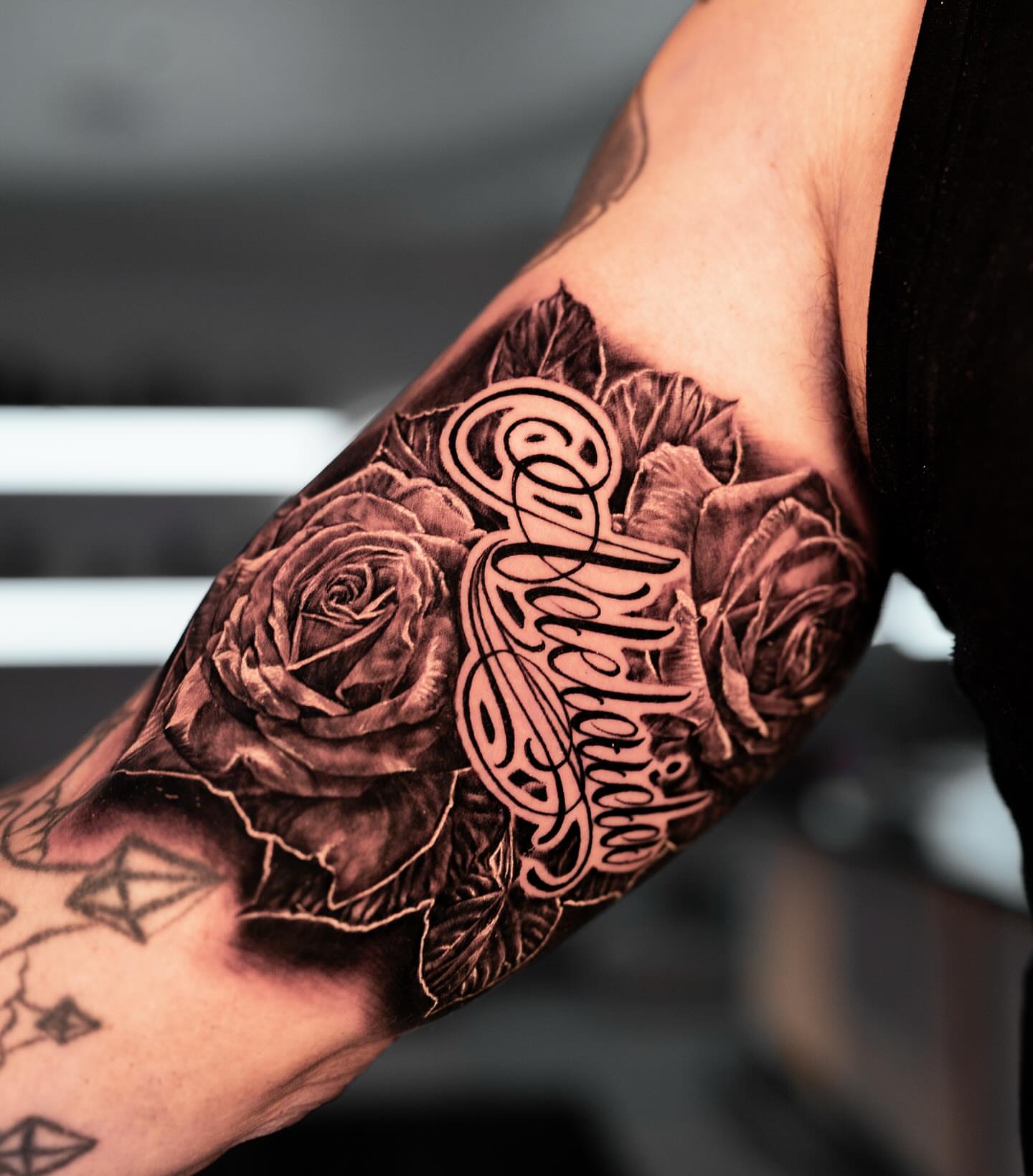 Roses and cursive script realism tattoo on the forearm by Stacy Lavette