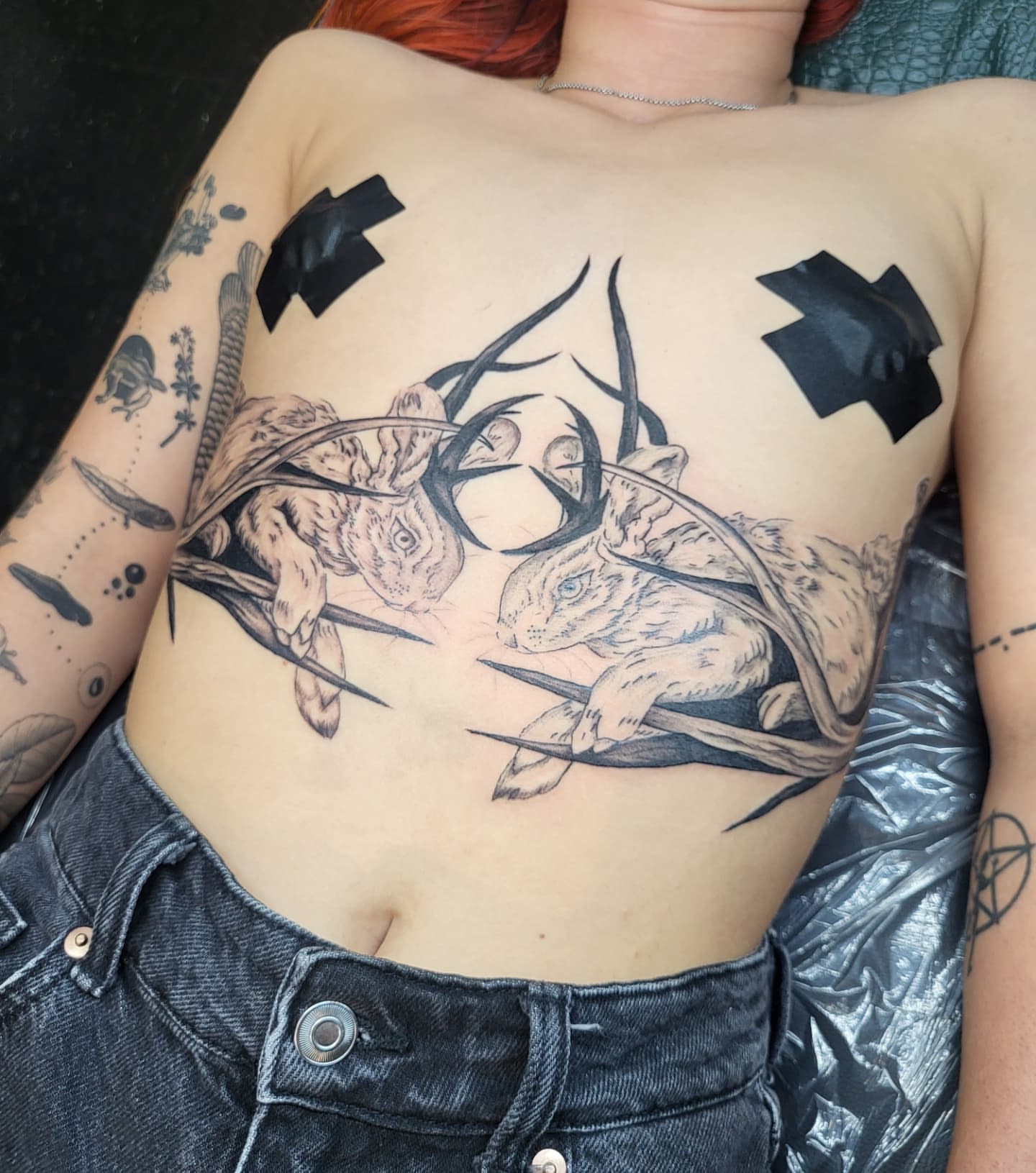 Rabbits black and grey tattoo on the chest by Jenna 🖤 Tattoos Denton TX