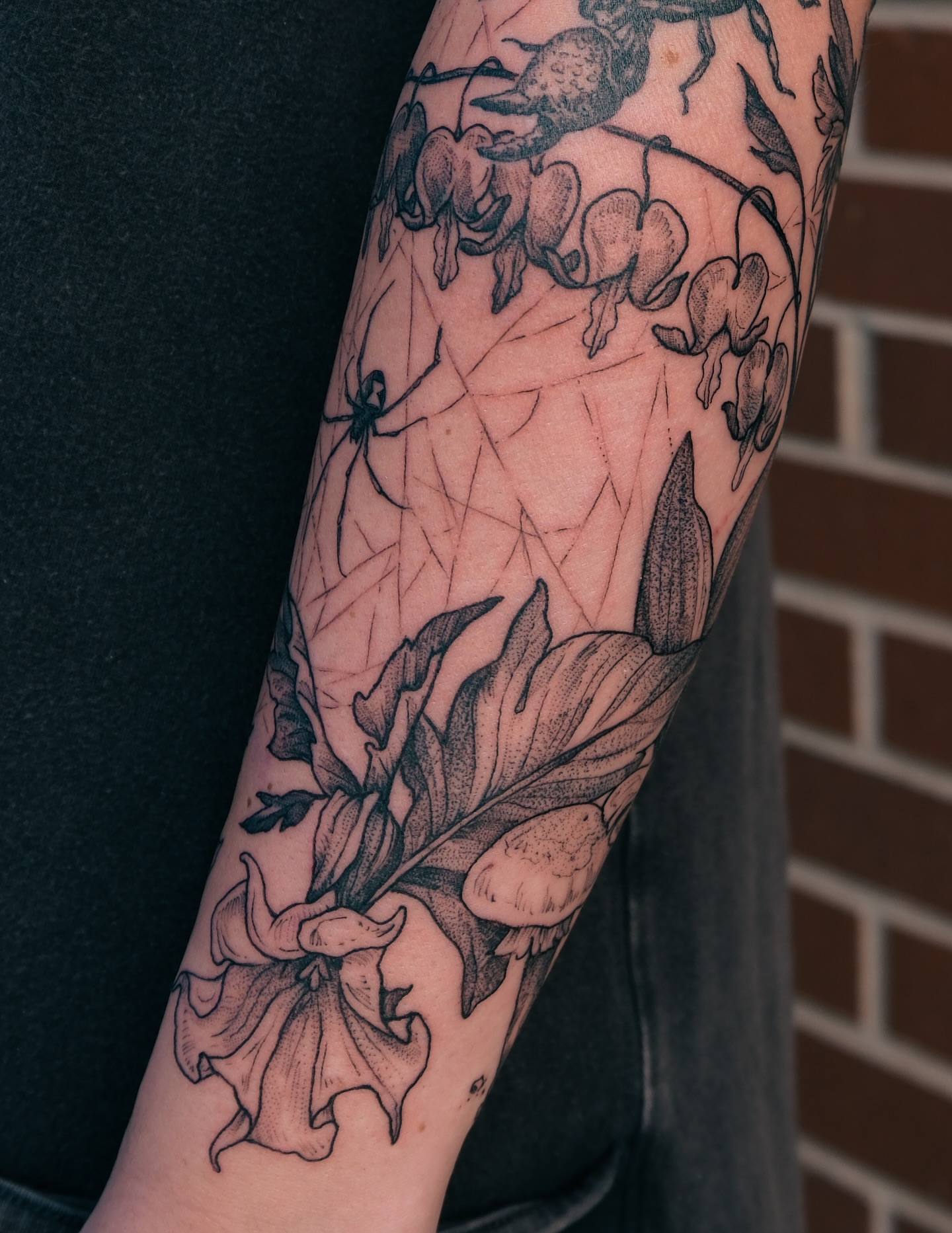 Lilies and spider realism tattoo on the forearm by Renee (Koi) Vance