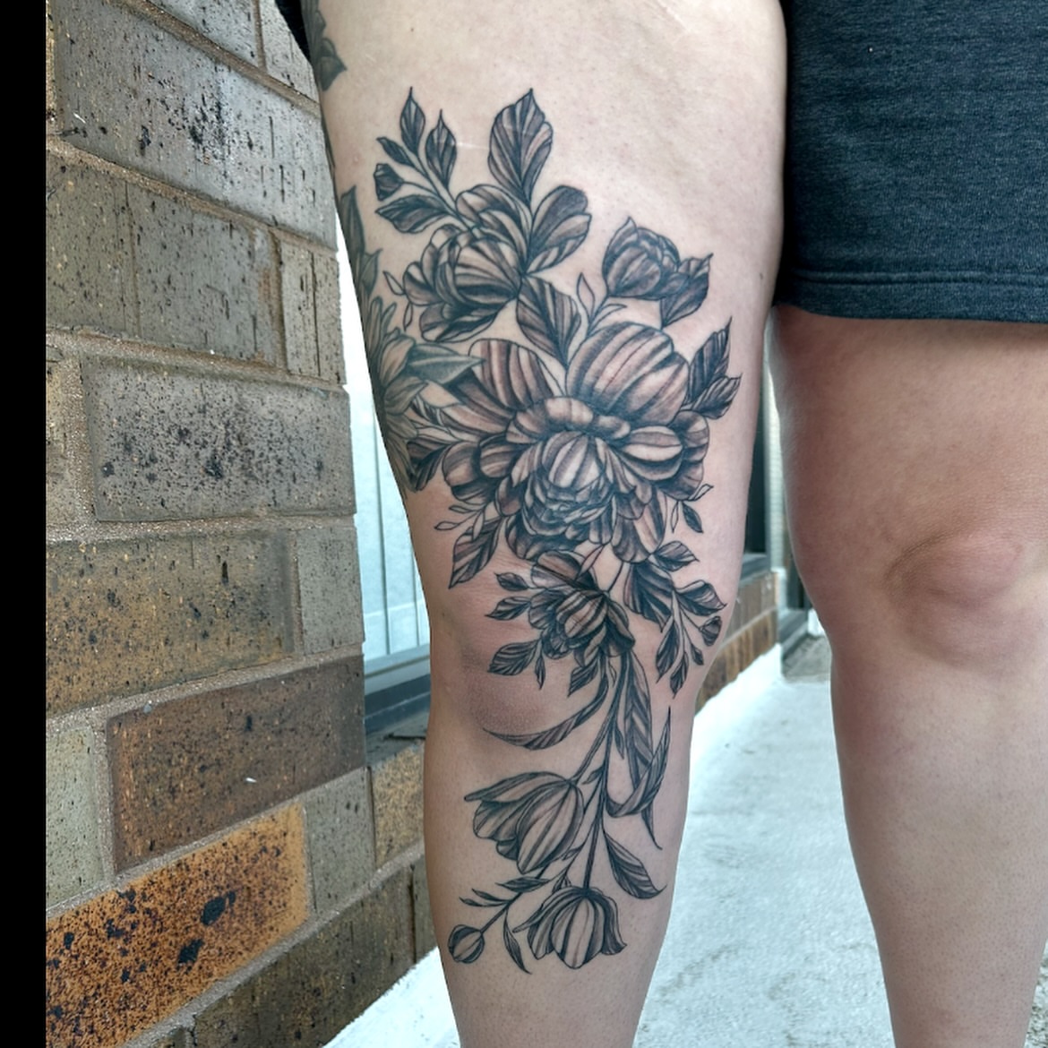 Floral bouquet black and grey tattoo on the thigh by Brittany Brutal