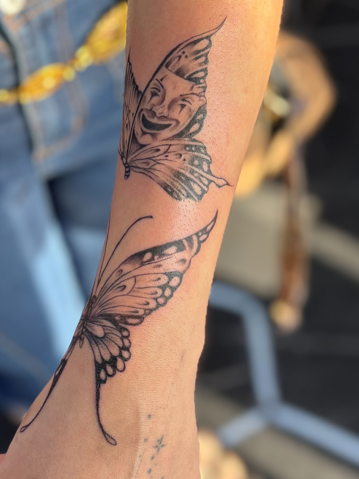 Butterfly and face black and grey tattoo on the forearm by $weet little leslie 🩶🧚🏻‍♀️