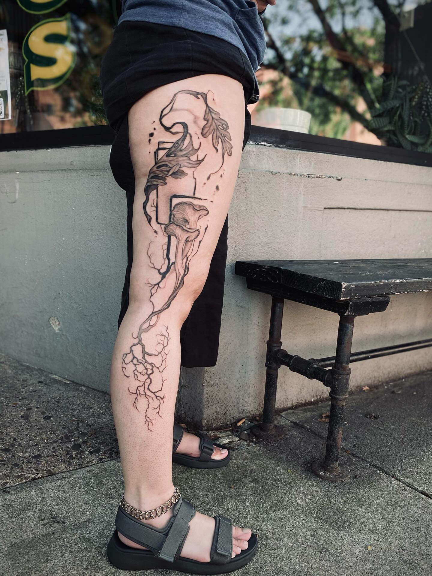 Root system black and grey tattoo on the leg by Dana Jones