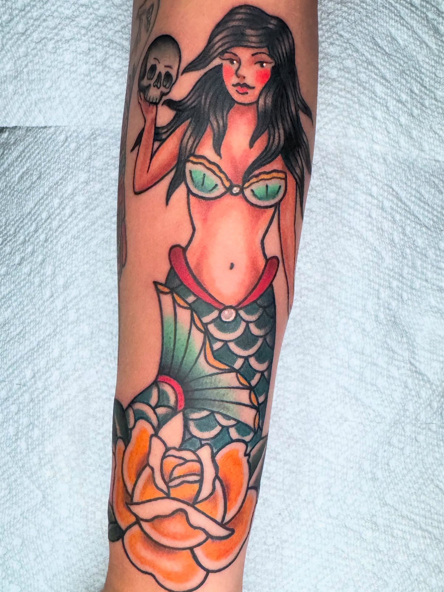 Mermaid with skull American traditional tattoo on the forearm by Lisa Del Toro