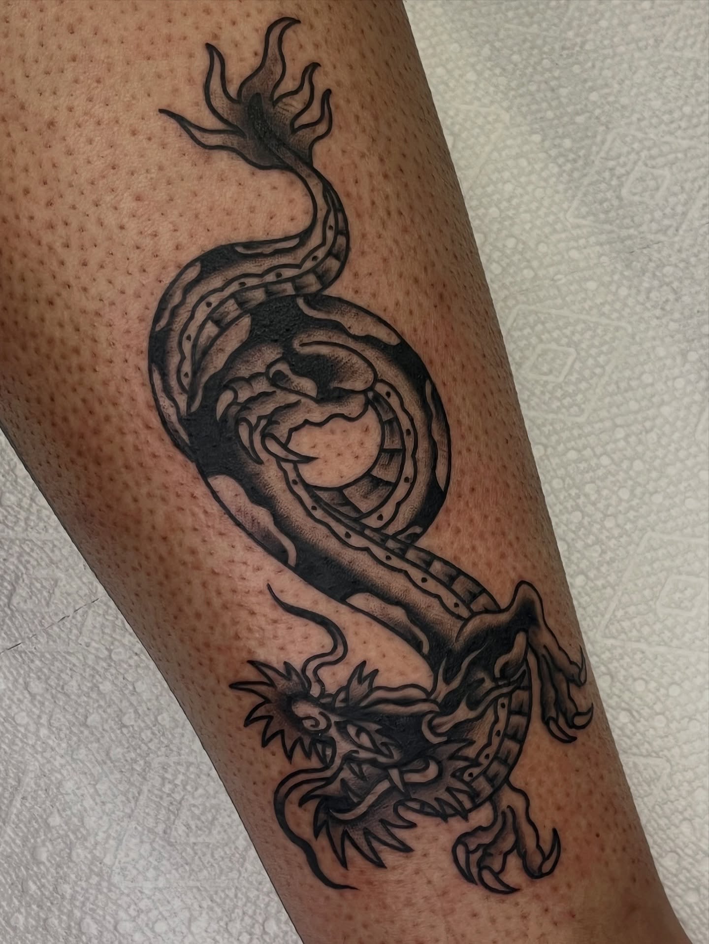 Dragon black and grey tattoo on the forearm by August B., Renton, Washington