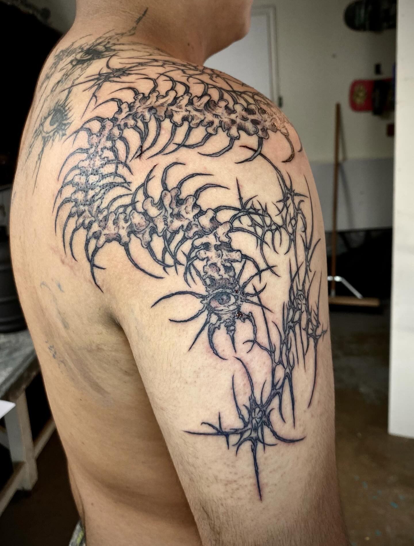 Eye and thorns black and grey tattoo on the shoulder by Quin Walker
