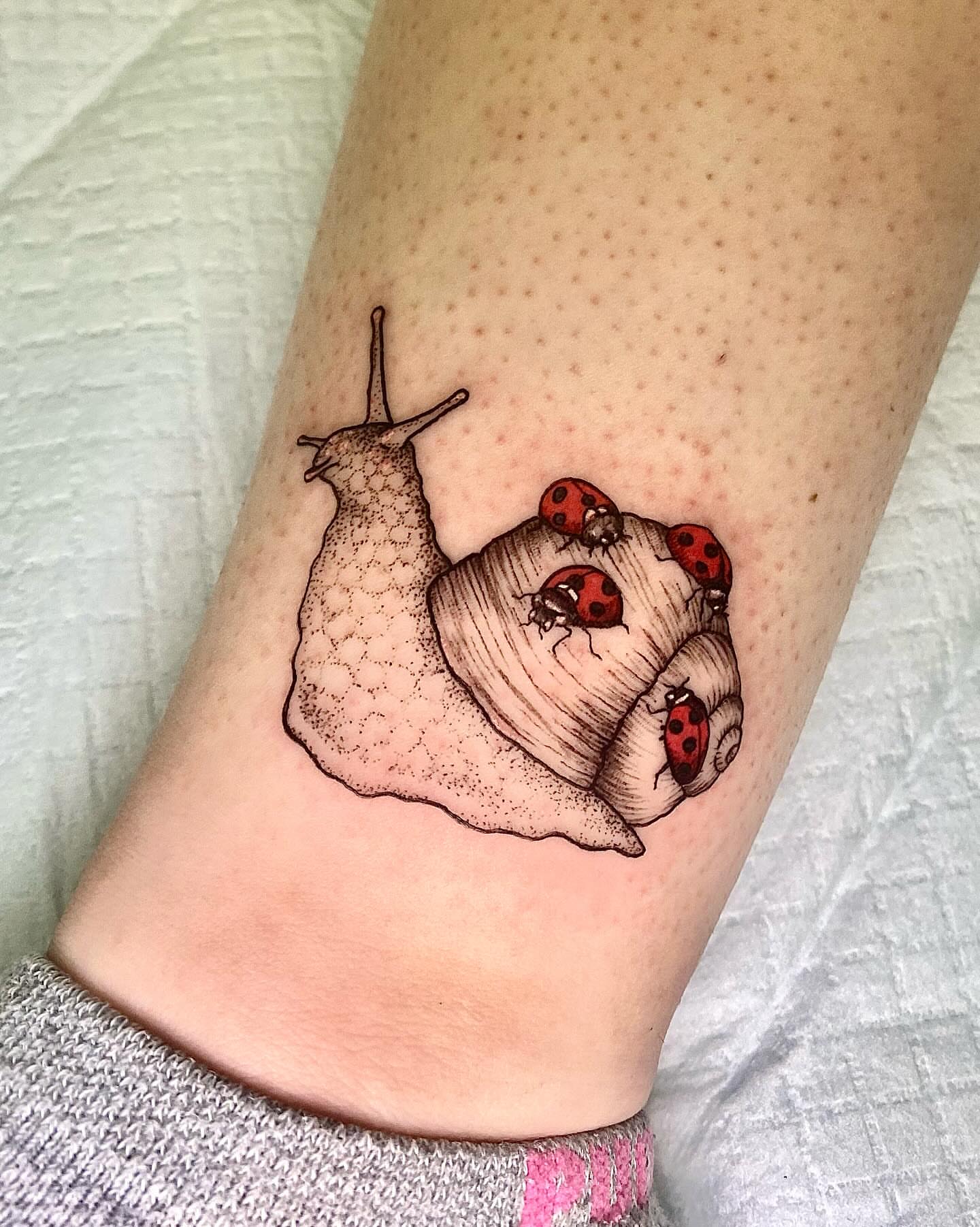 Snail with ladybugs realism tattoo on the forearm by Tyla Pistak, Seattle, Washington