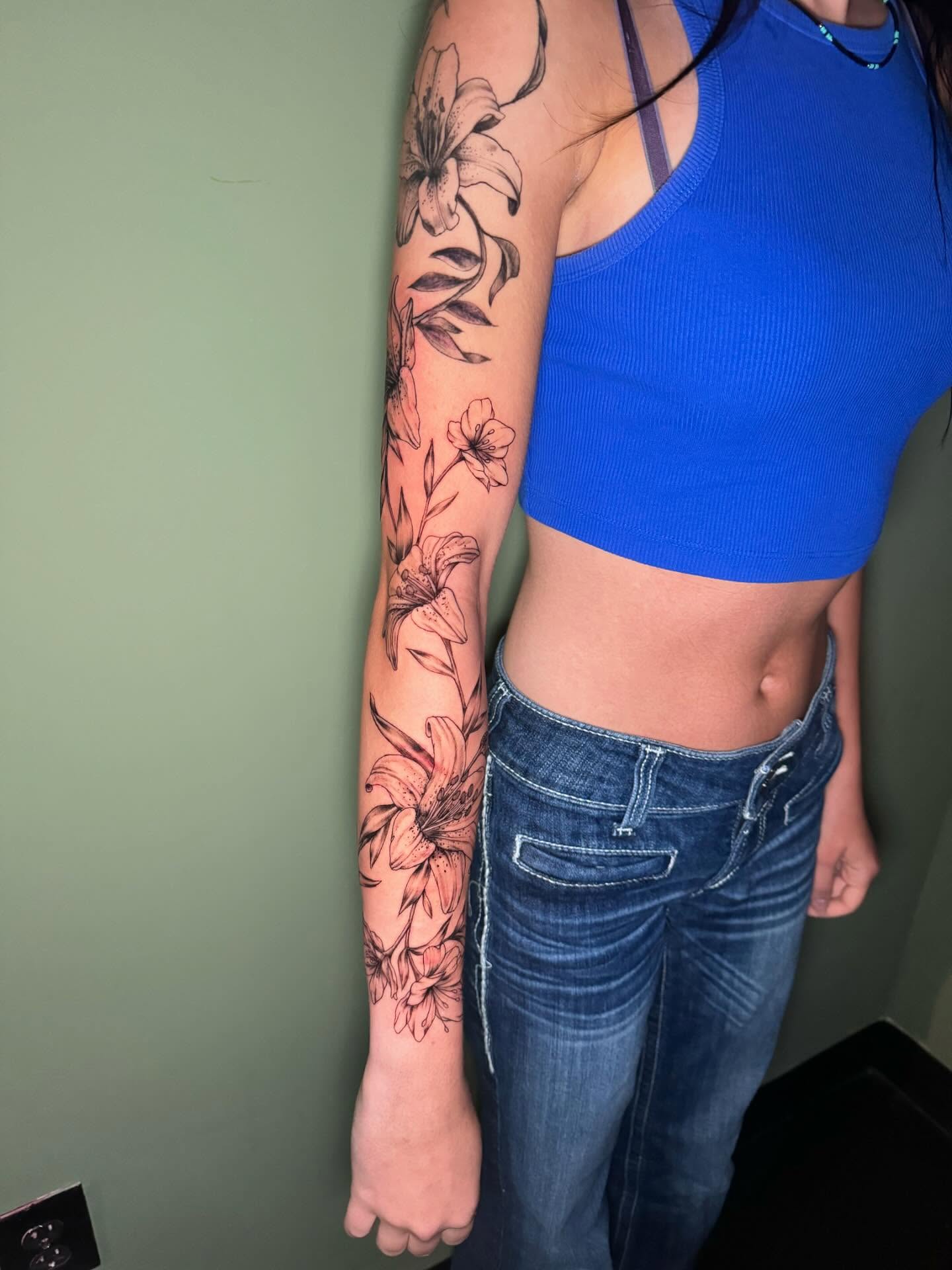 Floral arrangement black and grey tattoo on the forearm by Kenzie🖤
