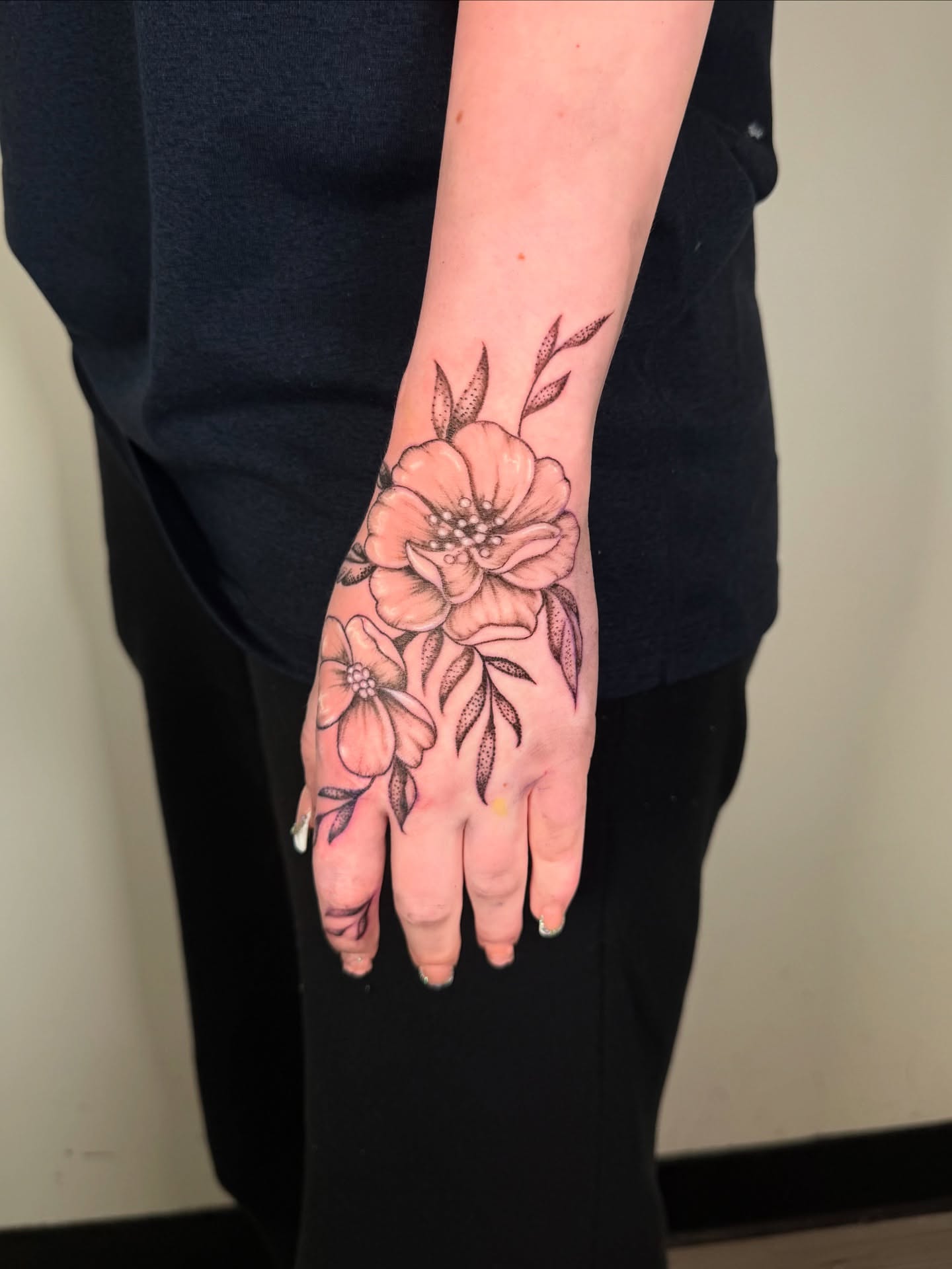Flowers black and grey tattoo on the hand by Diana