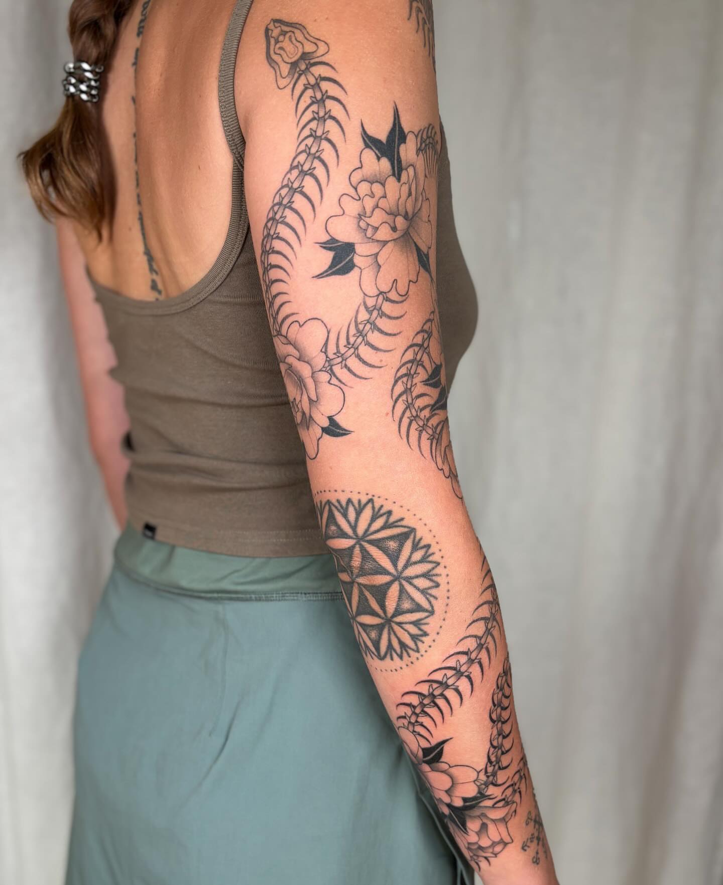 Snake and peony dotwork tattoo on the upper arm by Anna Sage