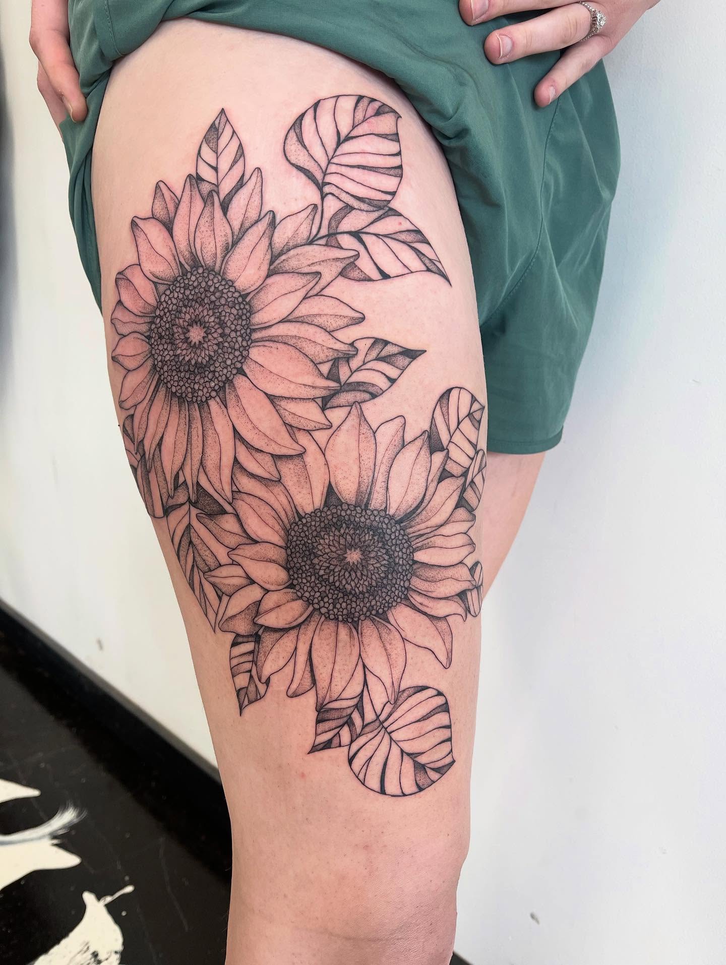 Sunflowers black and grey tattoo on the thigh by Miesha Busker