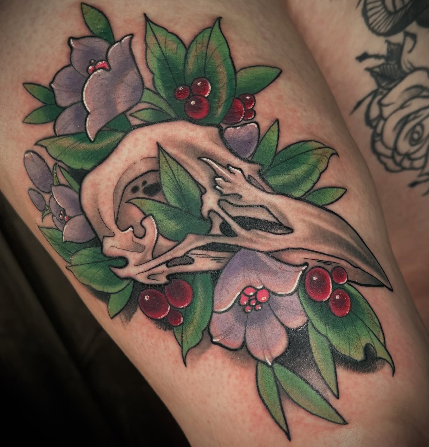 Deer skull and berries American traditional tattoo on the thigh by B.G. Germershausen
