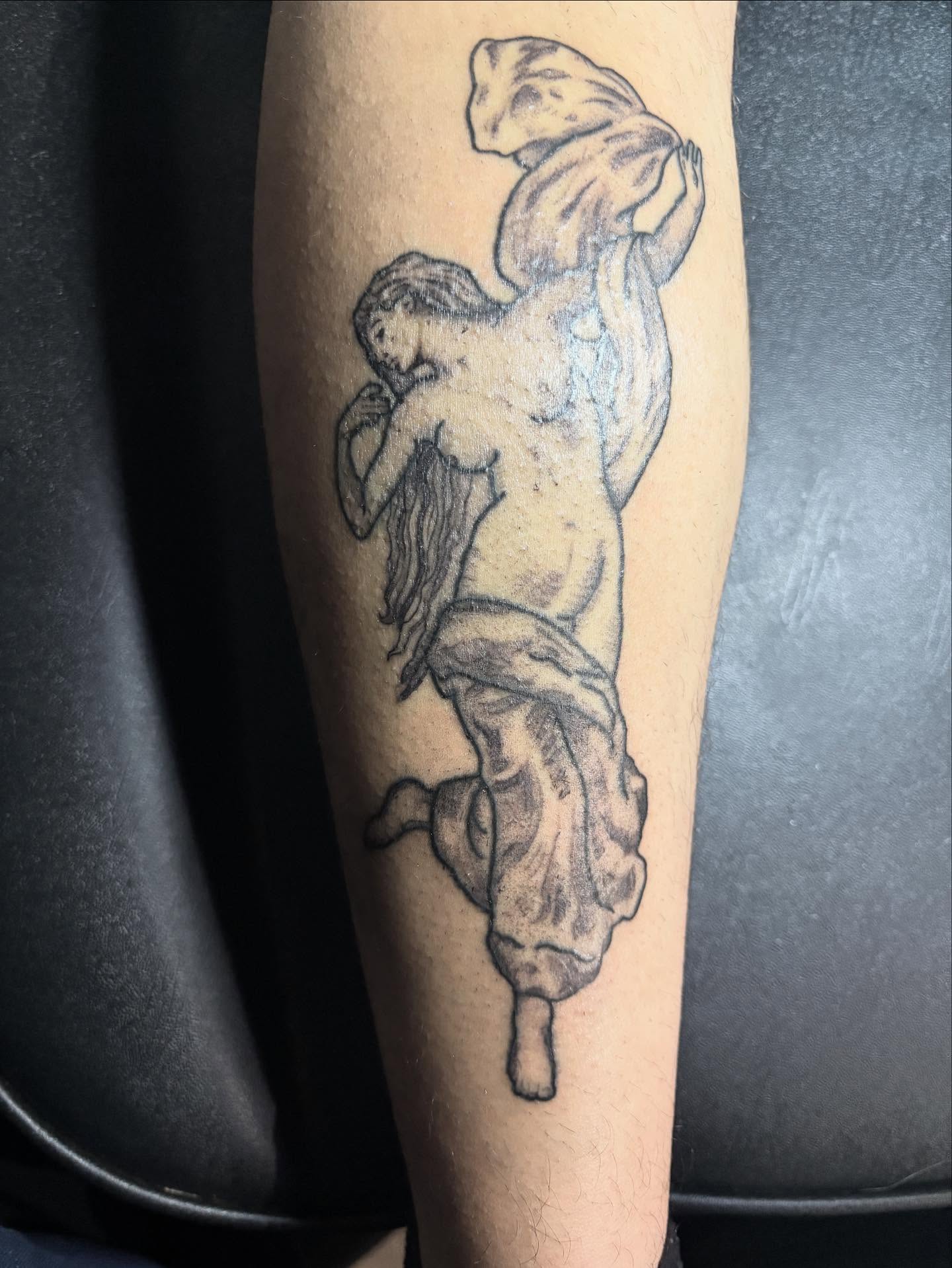 Statue of a man black and grey tattoo on the forearm by Angel Arceo