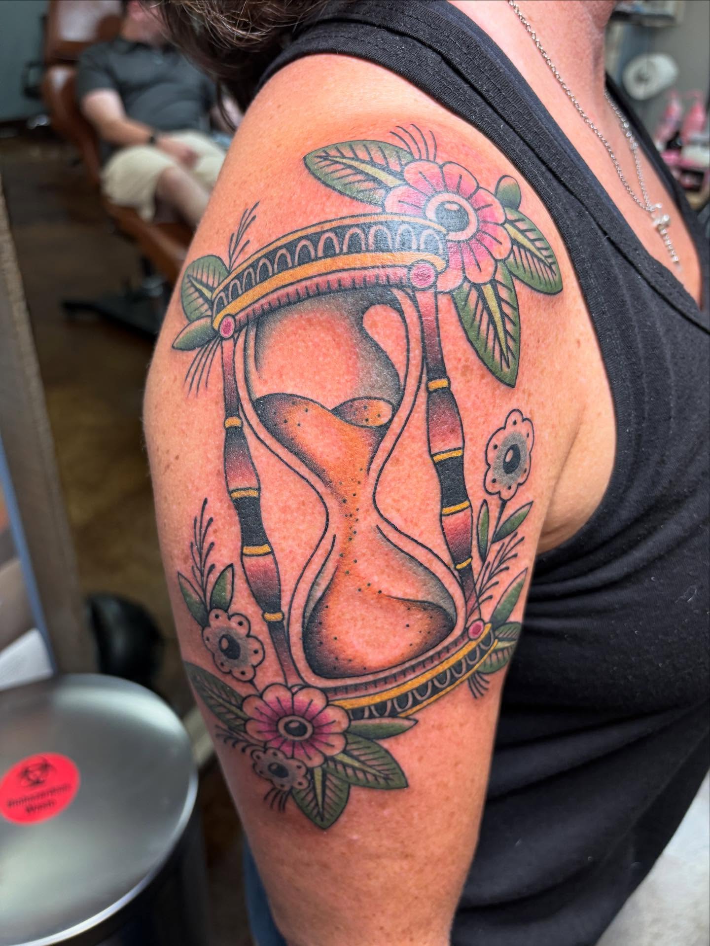 Hourglass with floral elements American traditional tattoo on the shoulder by Jakob Ristau, Kansas City, Missouri