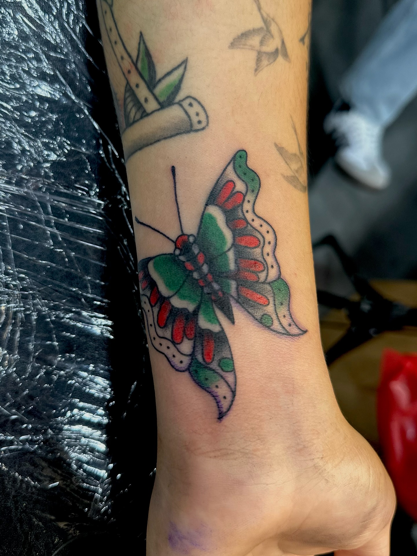 Butterfly American traditional tattoo on the forearm by Stacy Fevinger