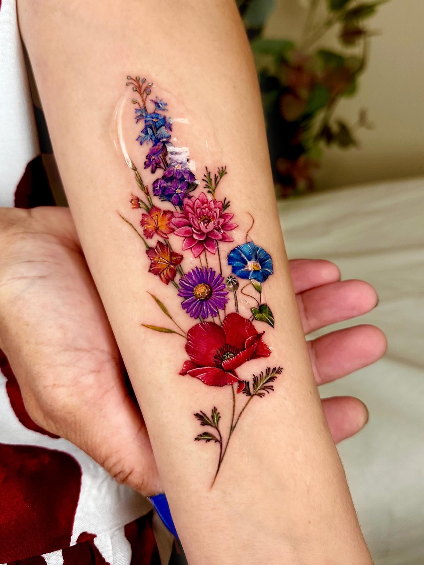 Floral bouquet realism tattoo on the forearm by Claire