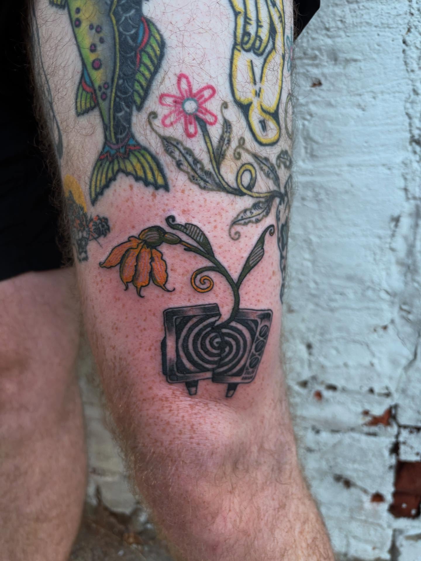 Fish, flower, hand, television American traditional tattoo on the forearm by kris noble floyd