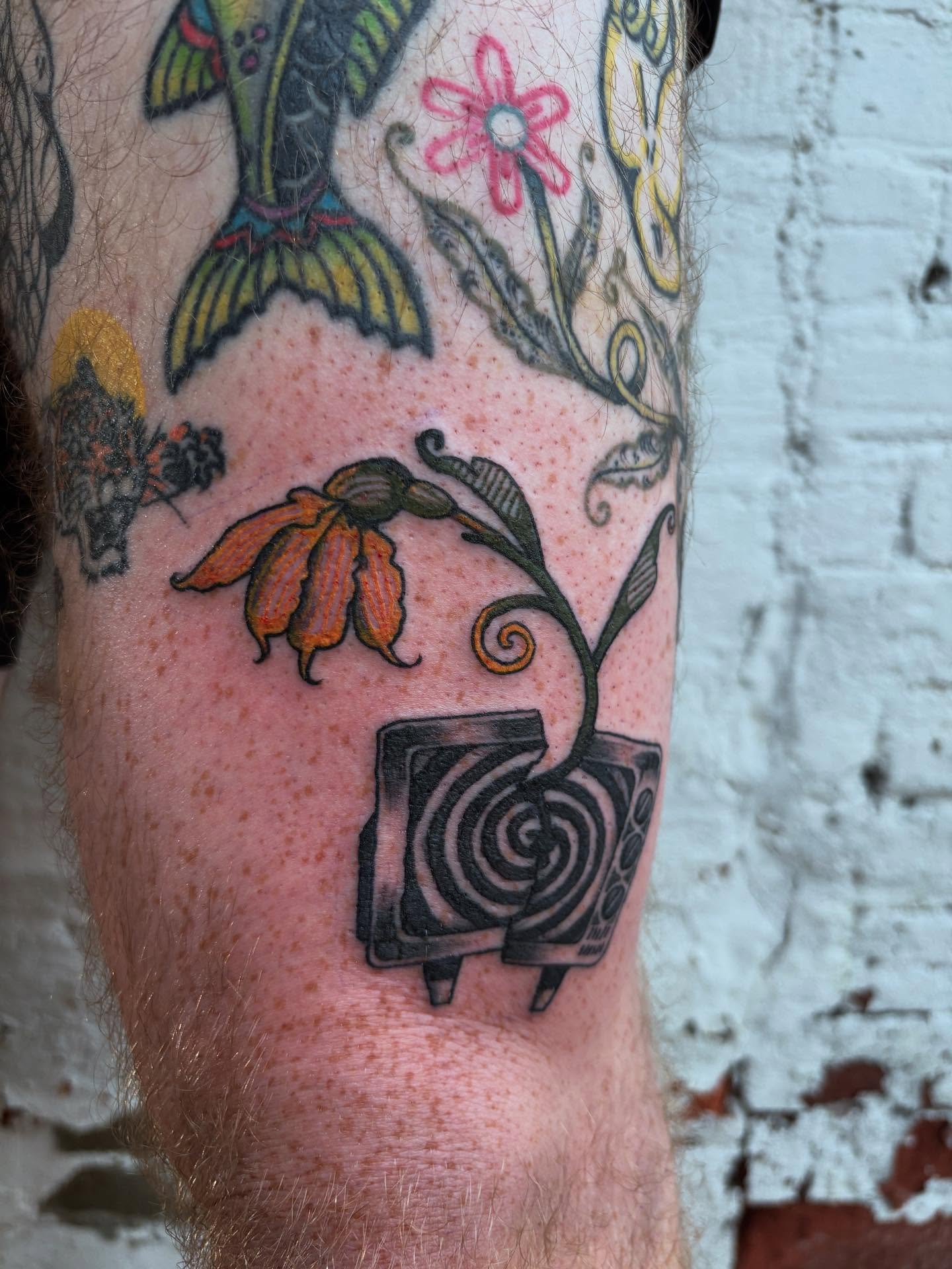 Television and flower new school tattoo on the forearm by kris noble floyd