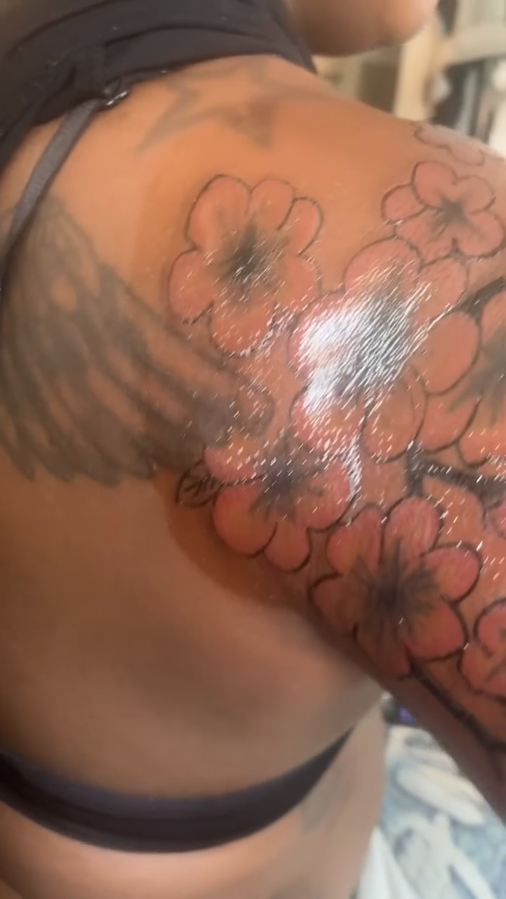 Cherry blossoms and an eye neo-traditional tattoo on the upper arm by Family and Loyalty