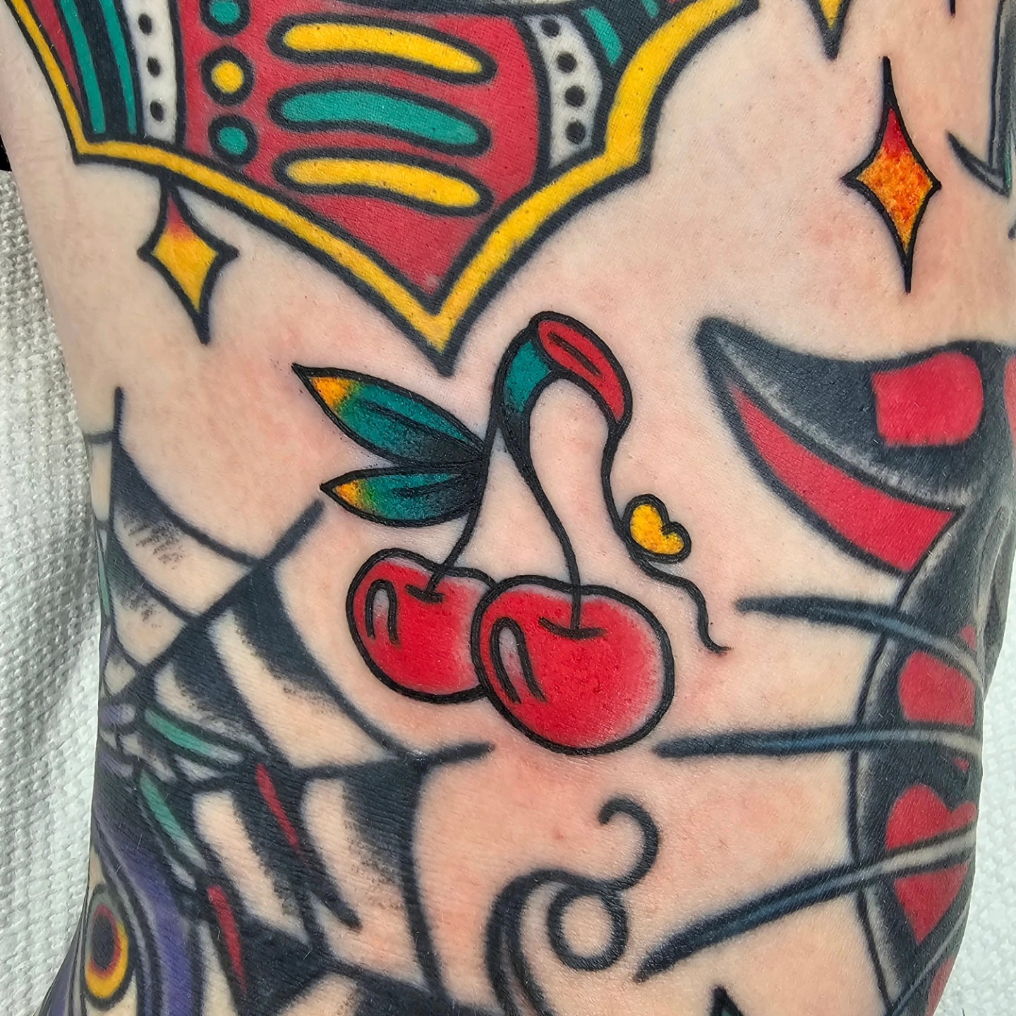 Cherry American traditional tattoo on the forearm by Adam Garnek
