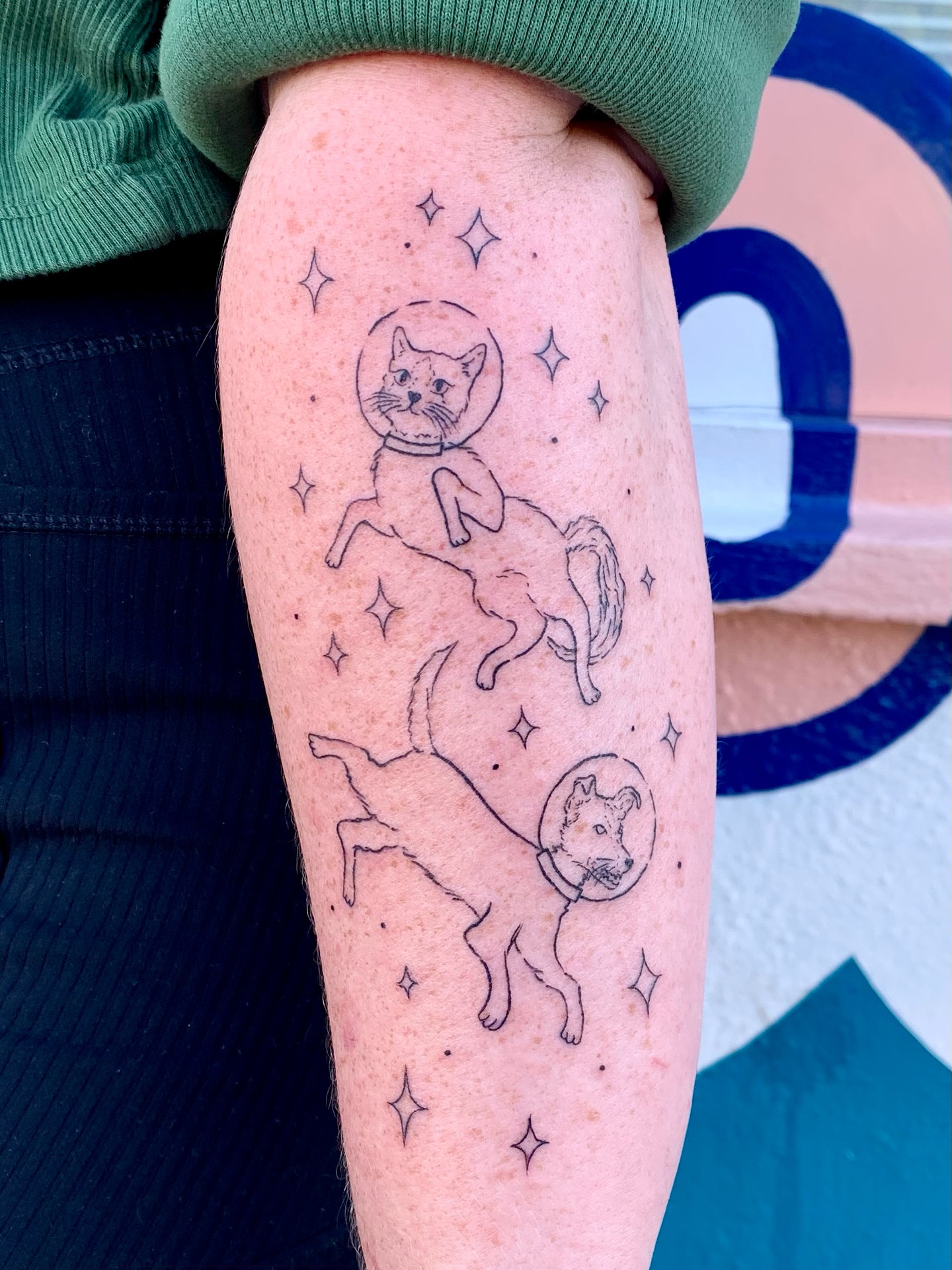 Astronaut cat and dog dotwork tattoo on the forearm by CharlieBoy