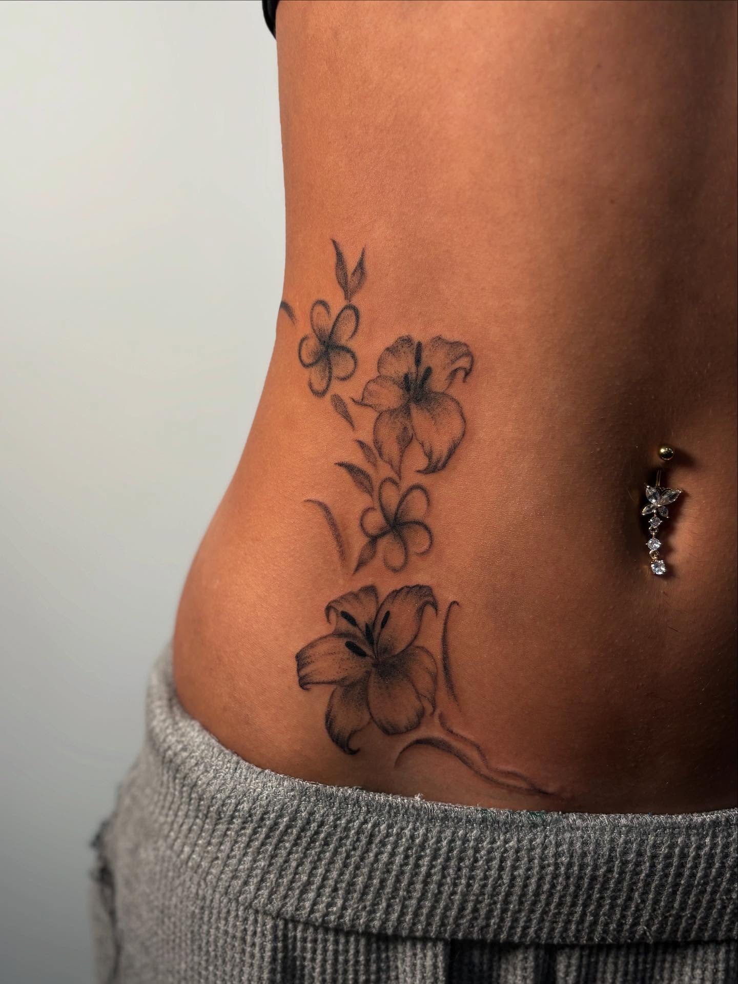 Lilies black and grey tattoo on the torso by Lee