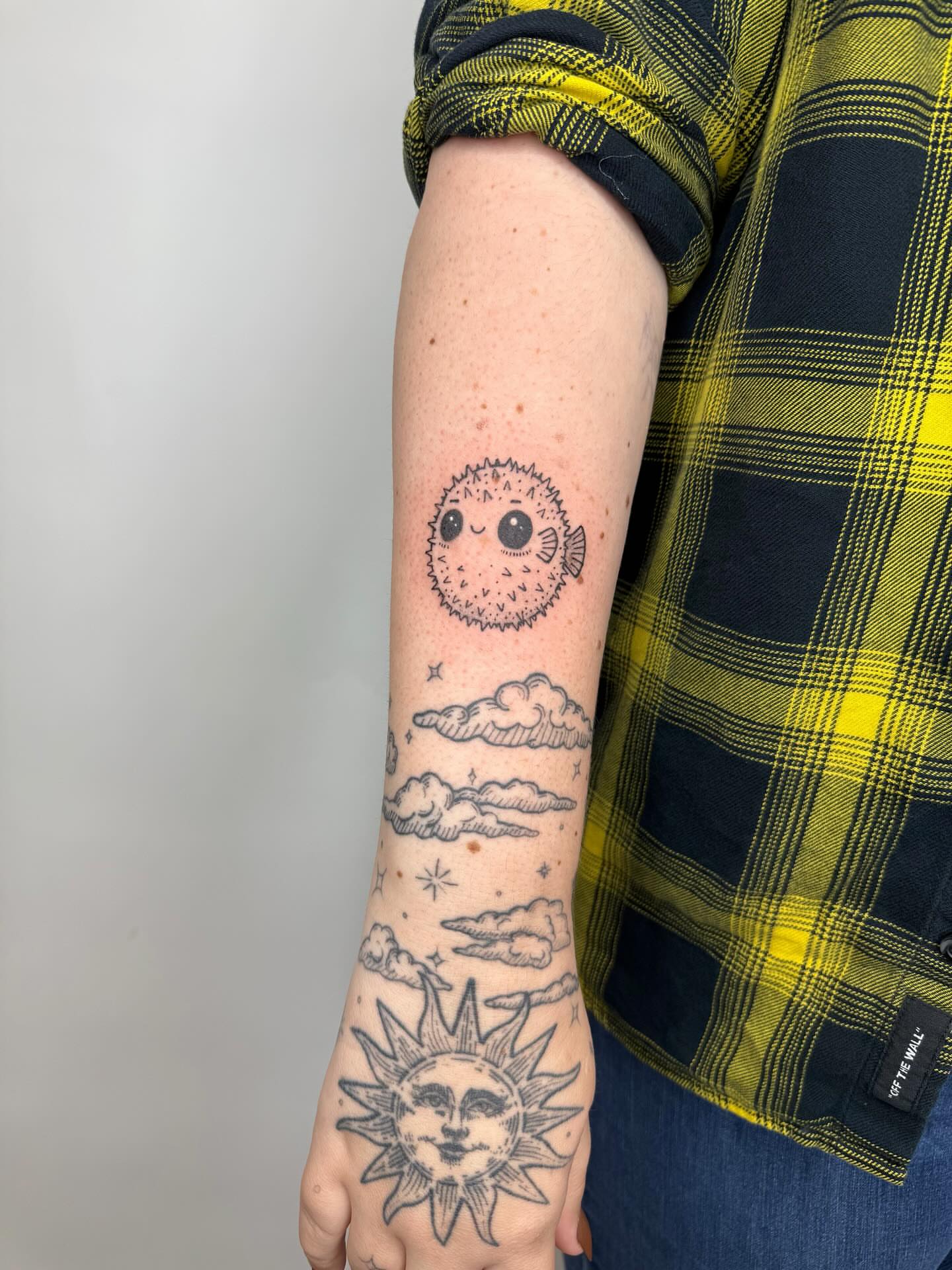 Sun and clouds black and grey tattoo on the forearm by Joey tattoo