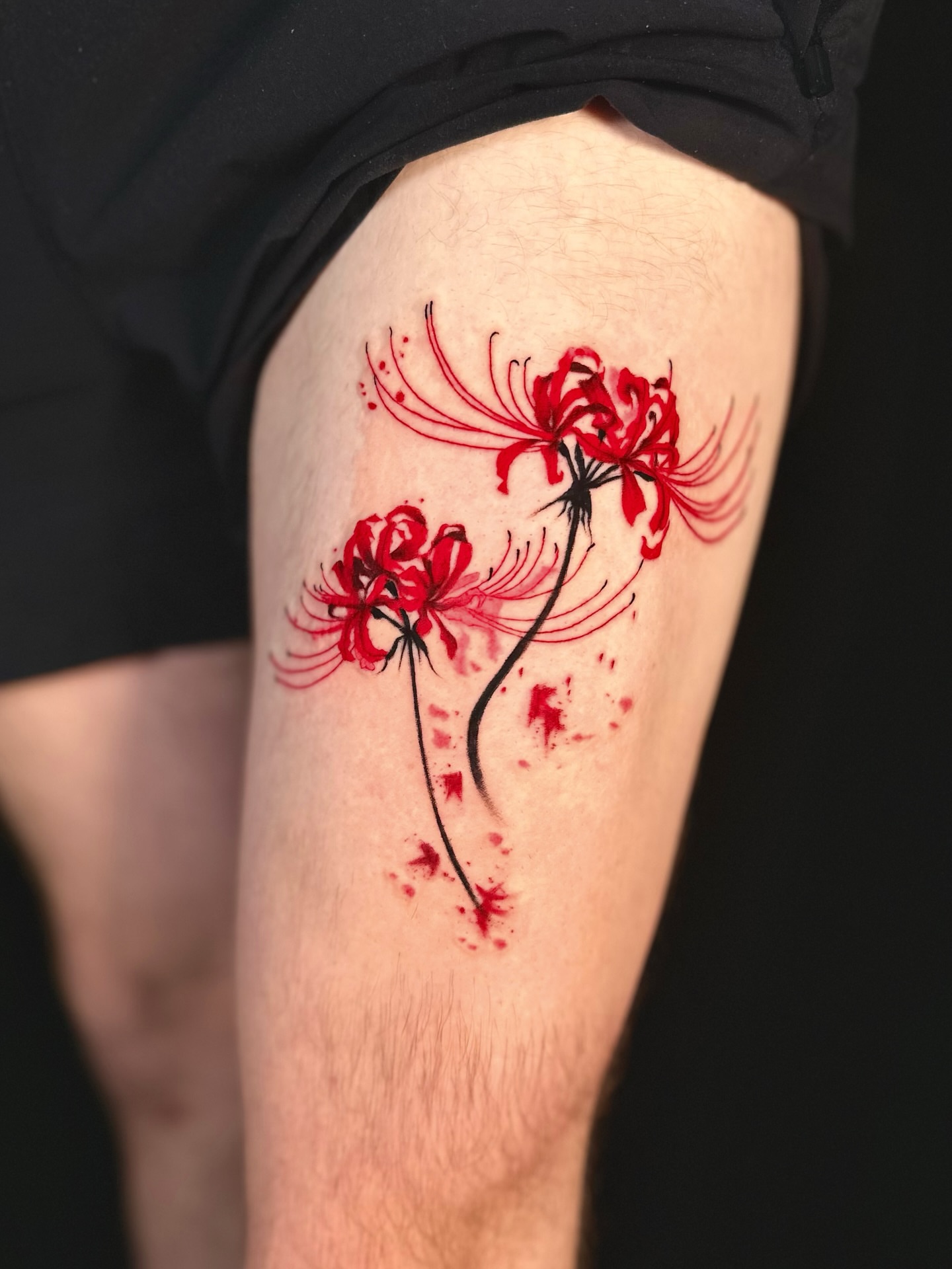 Clustered red flowers watercolor tattoo on the thigh by Abi