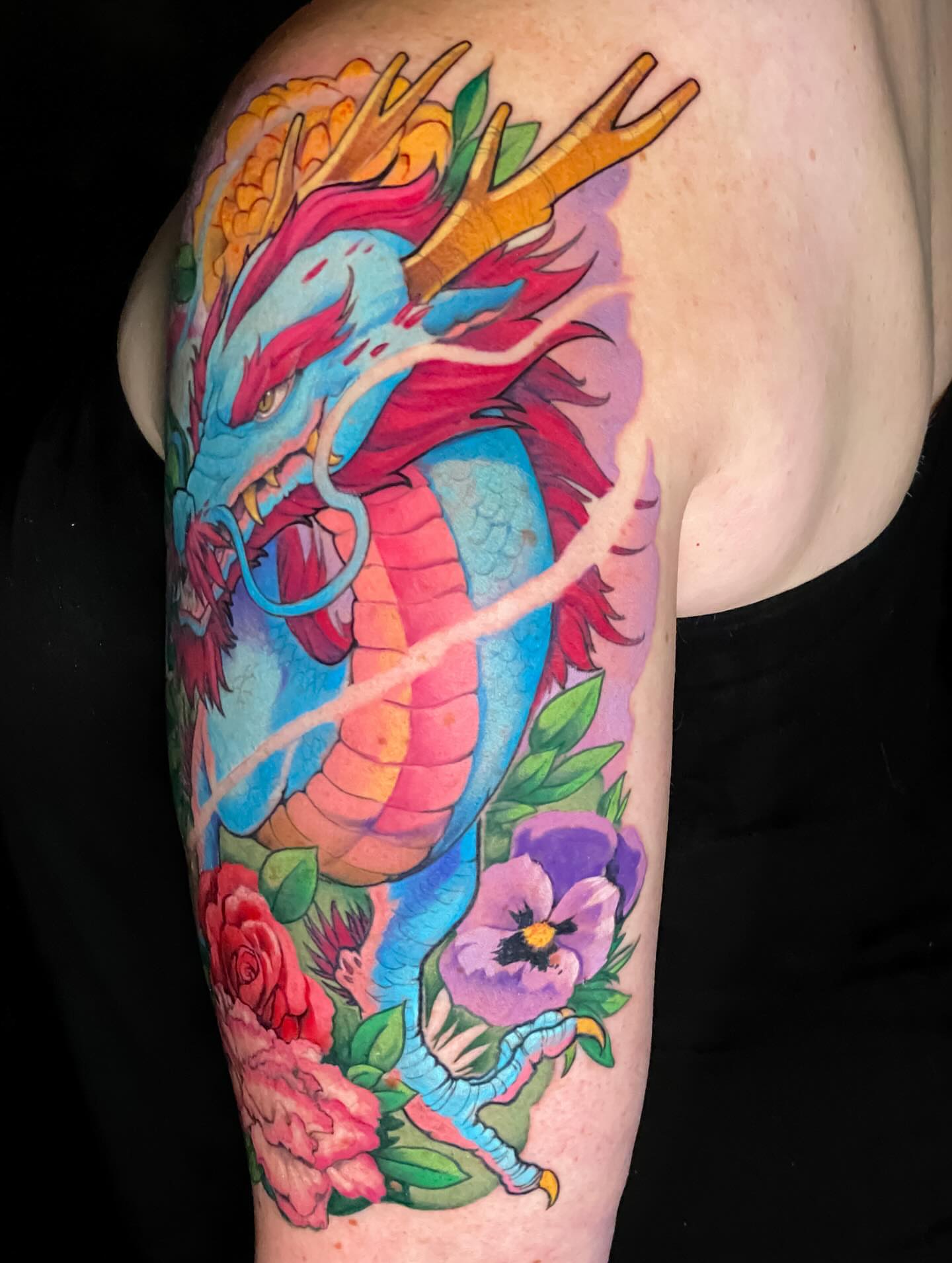 Dragon and flowers new school tattoo on the upper arm by Picasso Dular, Lake Forest, California
