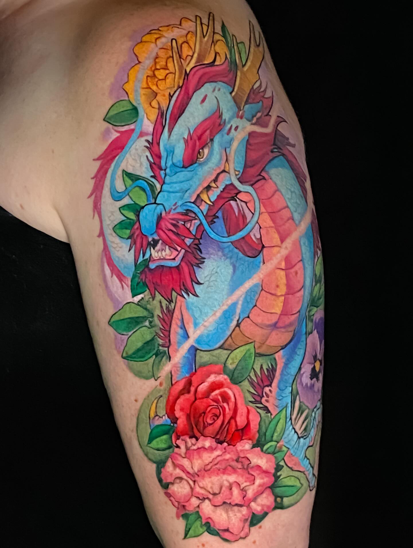 Dragon and flowers new school tattoo on the upper arm by Picasso Dular, Lake Forest, California