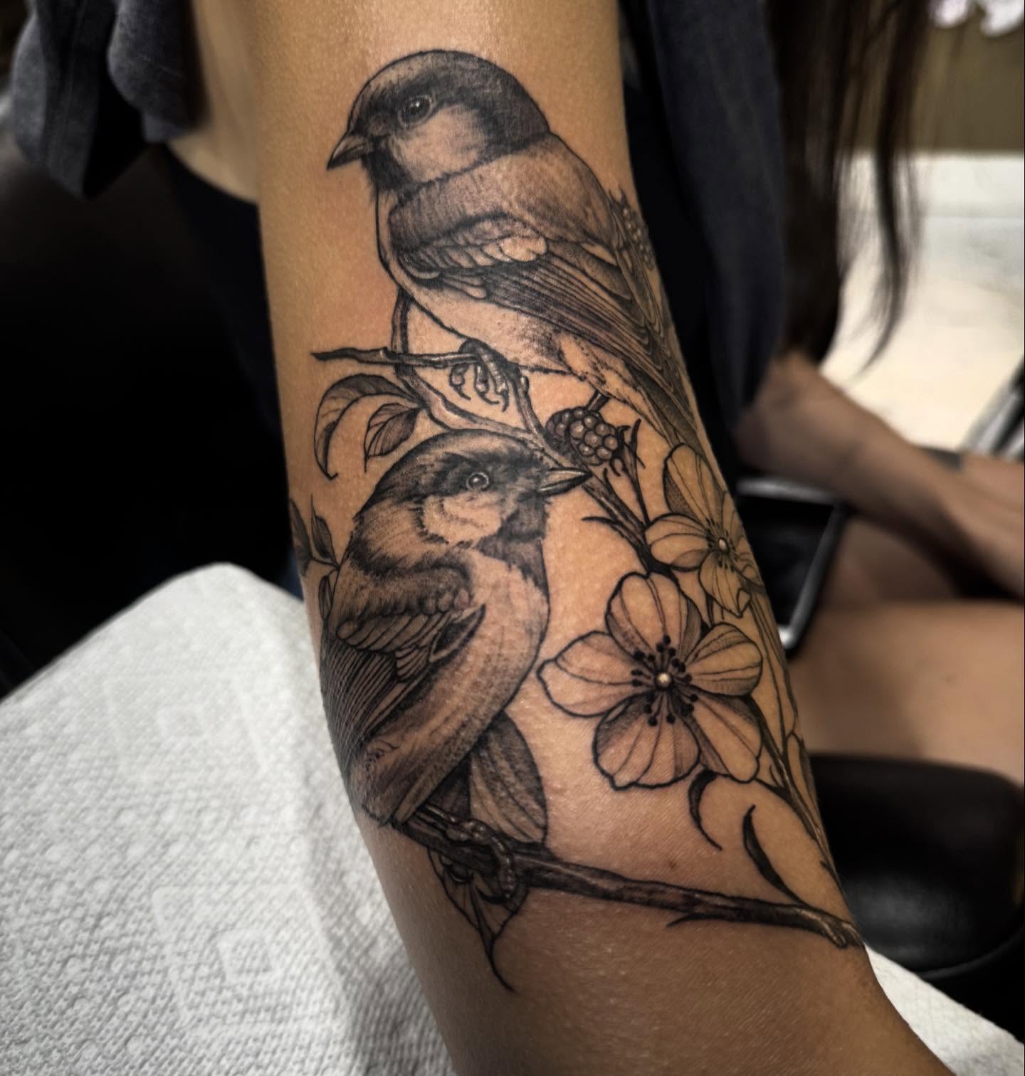 Birds and flowers realism tattoo on the forearm by Keith Smith