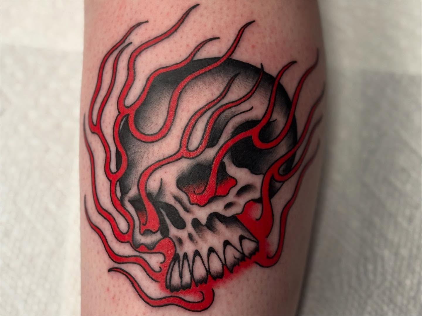 Flaming skull American traditional tattoo on the forearm by Tyler Whalen