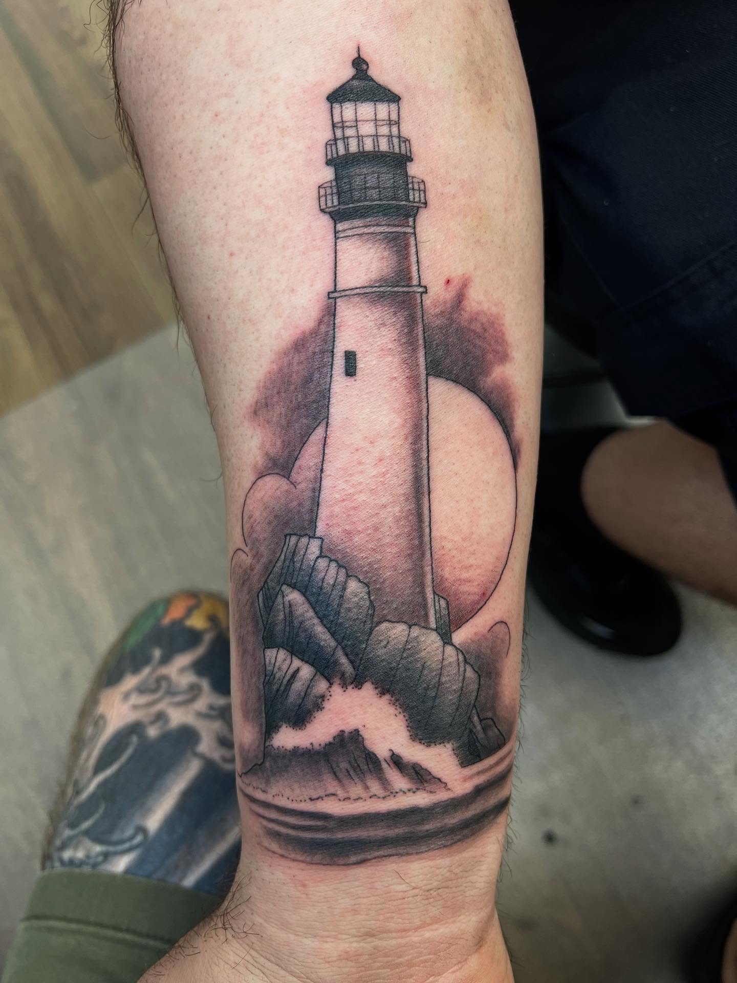 Lighthouse black and grey tattoo on the forearm by Cody Marl