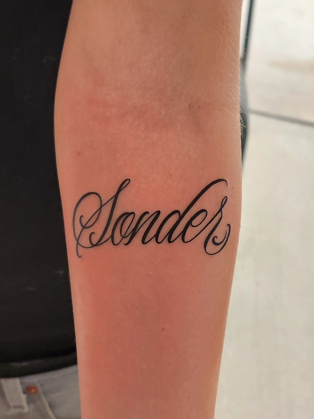 Sonder lettering script tattoo on the forearm by @youxg_guxxz