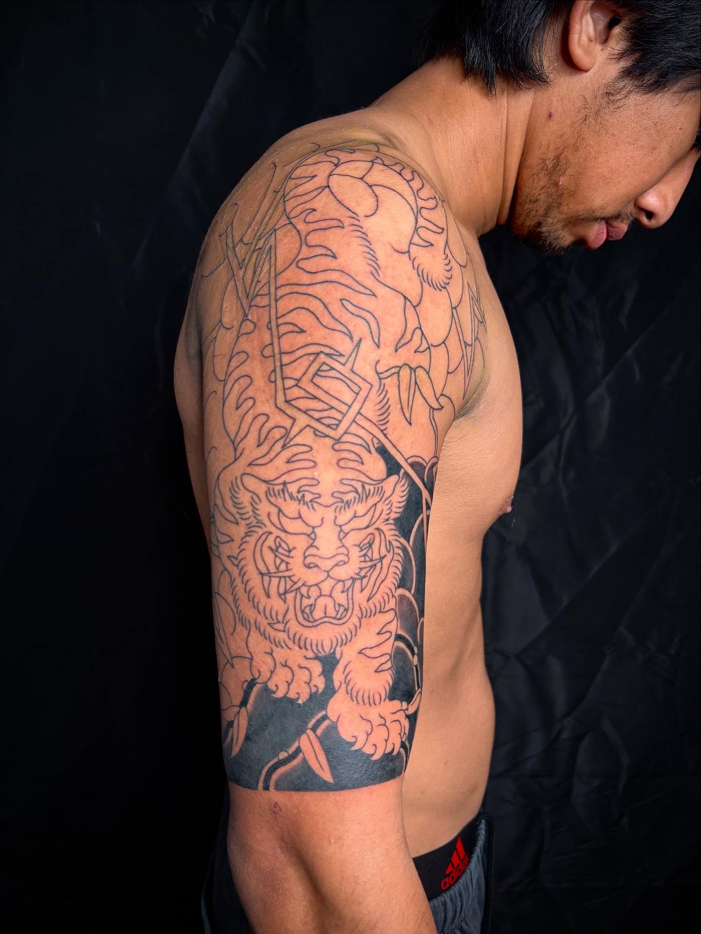 Tiger japanese irezumi tattoo on the upper arm by Zach Hendrickson