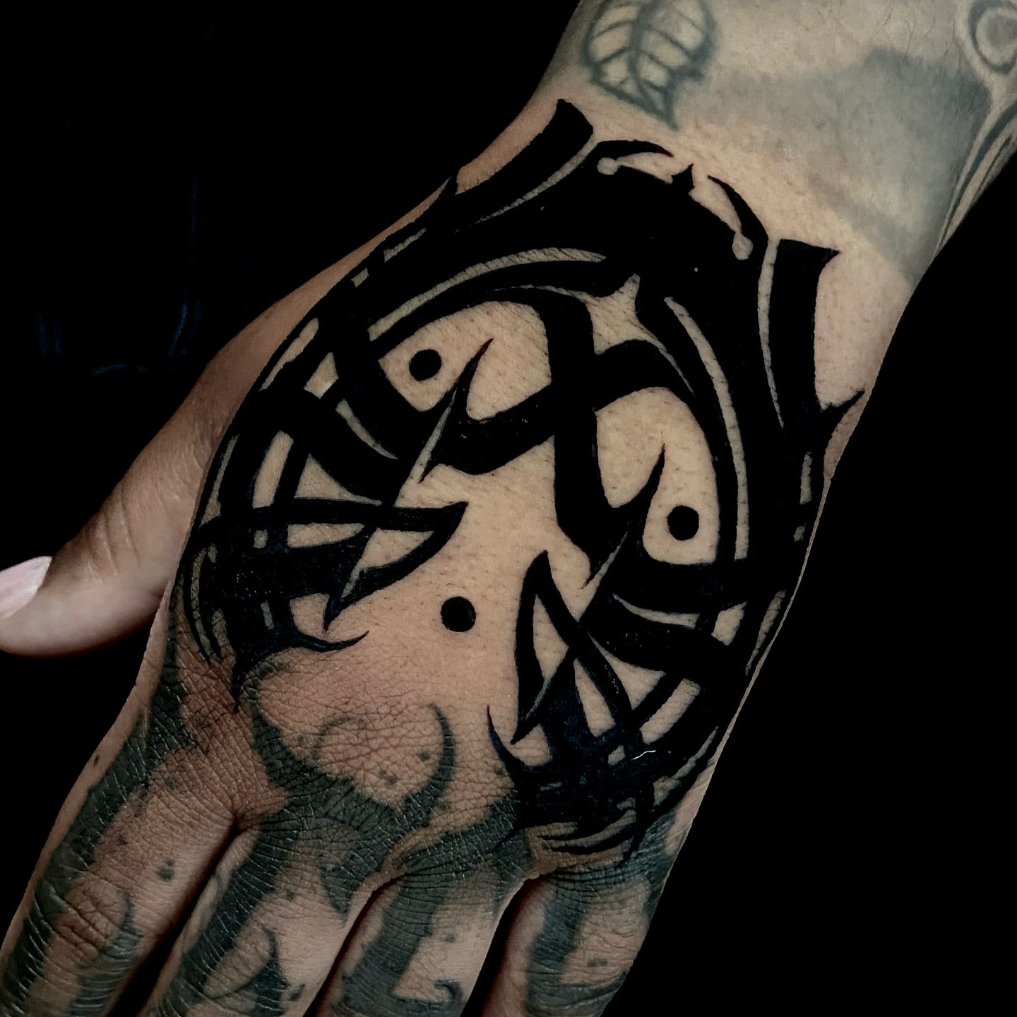 Abstract face black and grey tattoo on the hand by Nathan