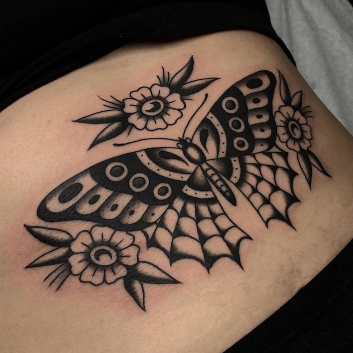 Butterfly and flowers American traditional tattoo on the thigh by Dakota Jenner