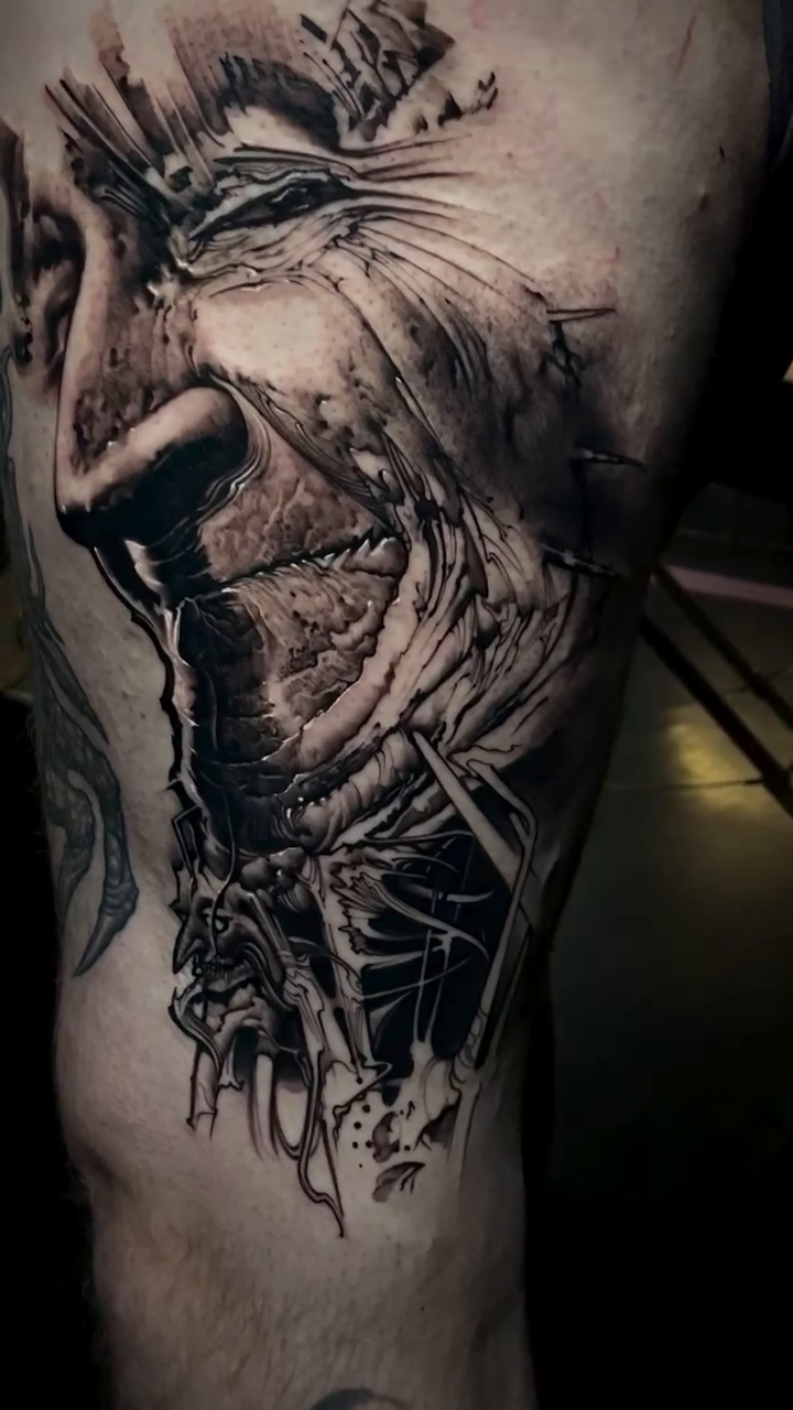 Distorted face dark realism tattoo by Robert Hernandez