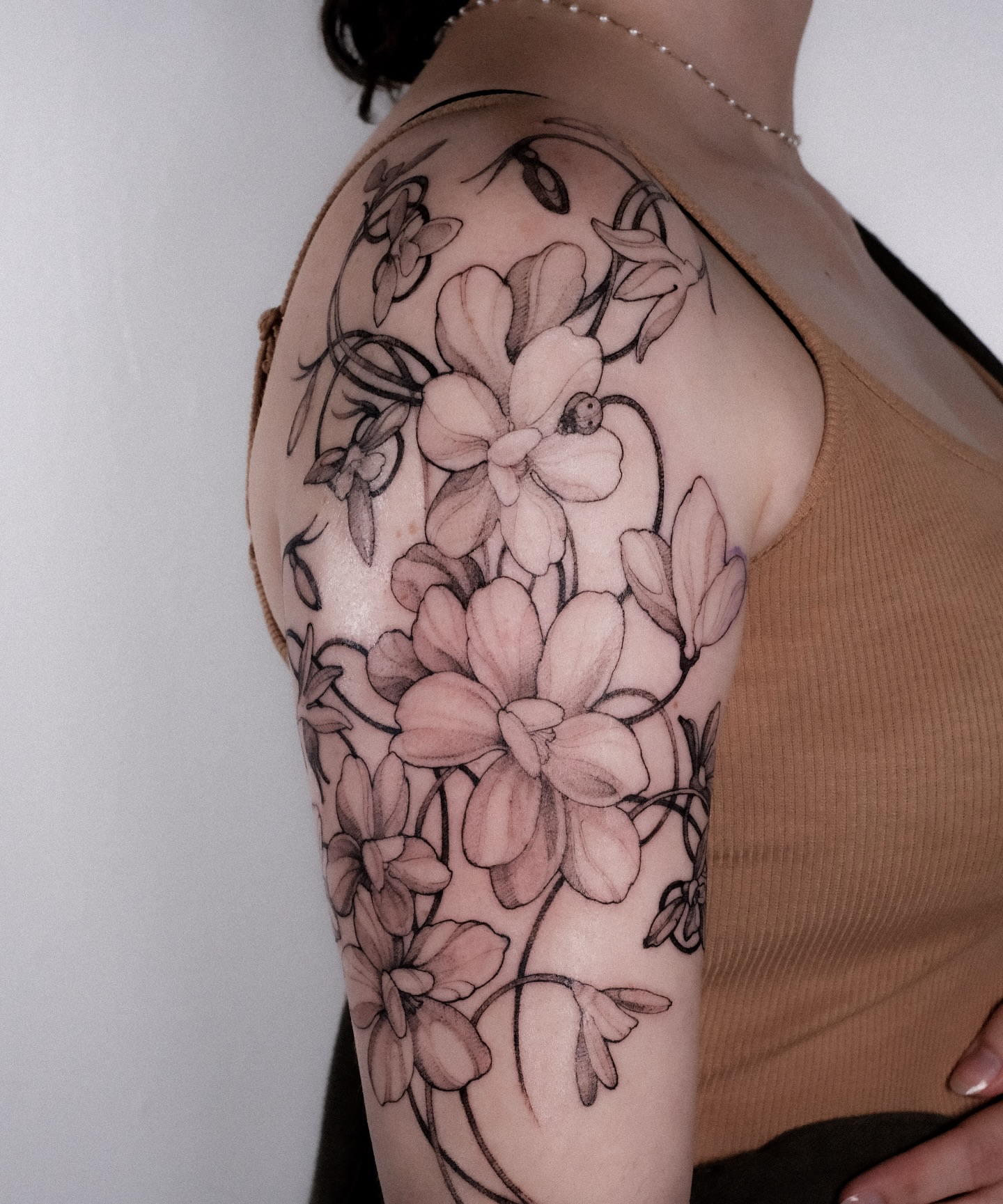 Floral bouquet black and grey tattoo on the shoulder by Alena Zozulenko