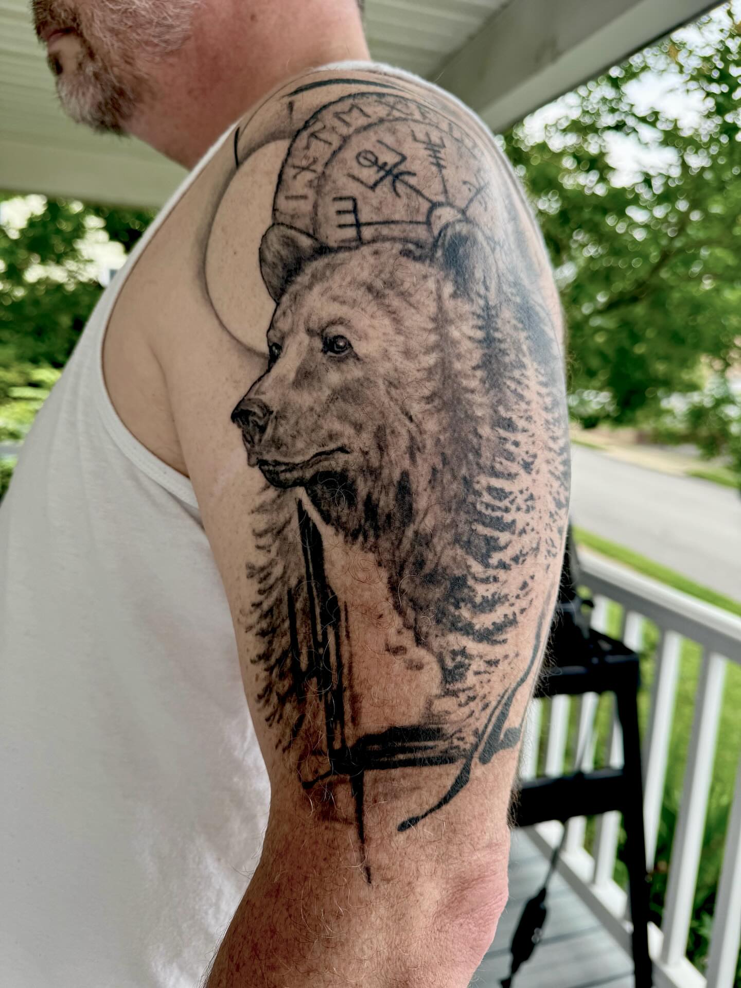 Bear realism tattoo on the upper arm by Dana Jones