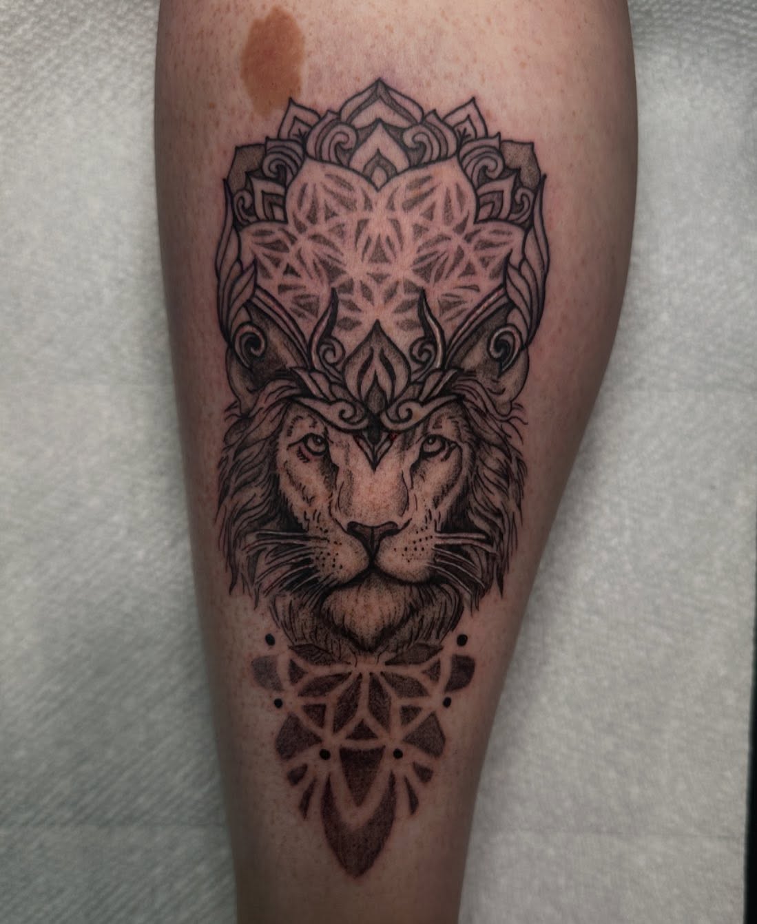Lion geometric tattoo on the forearm by Mika'la Berry