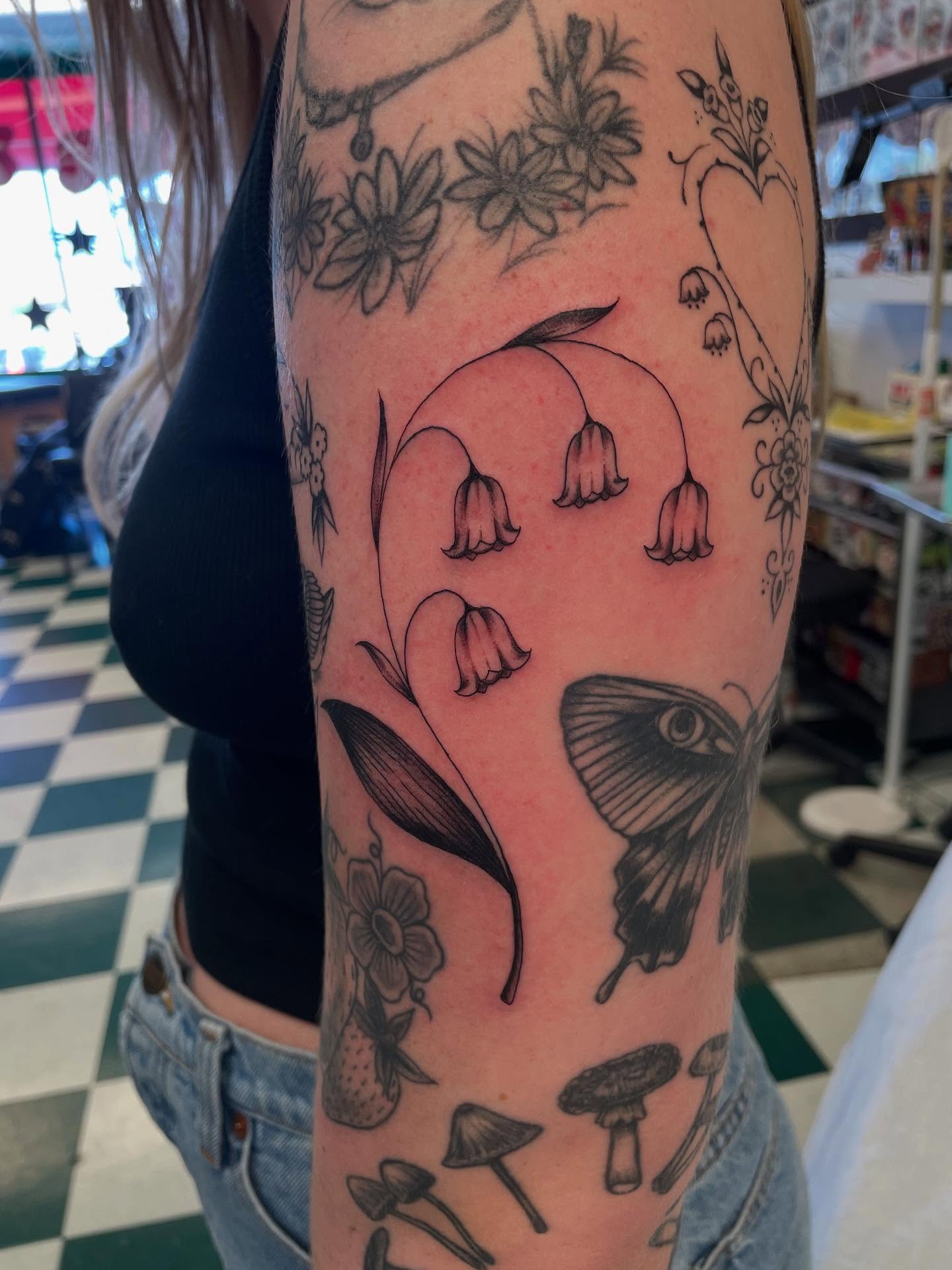 Lily of the valley and butterfly black and grey tattoo on the forearm by Dayton Tattoo Artist, Miamisburg, Ohio