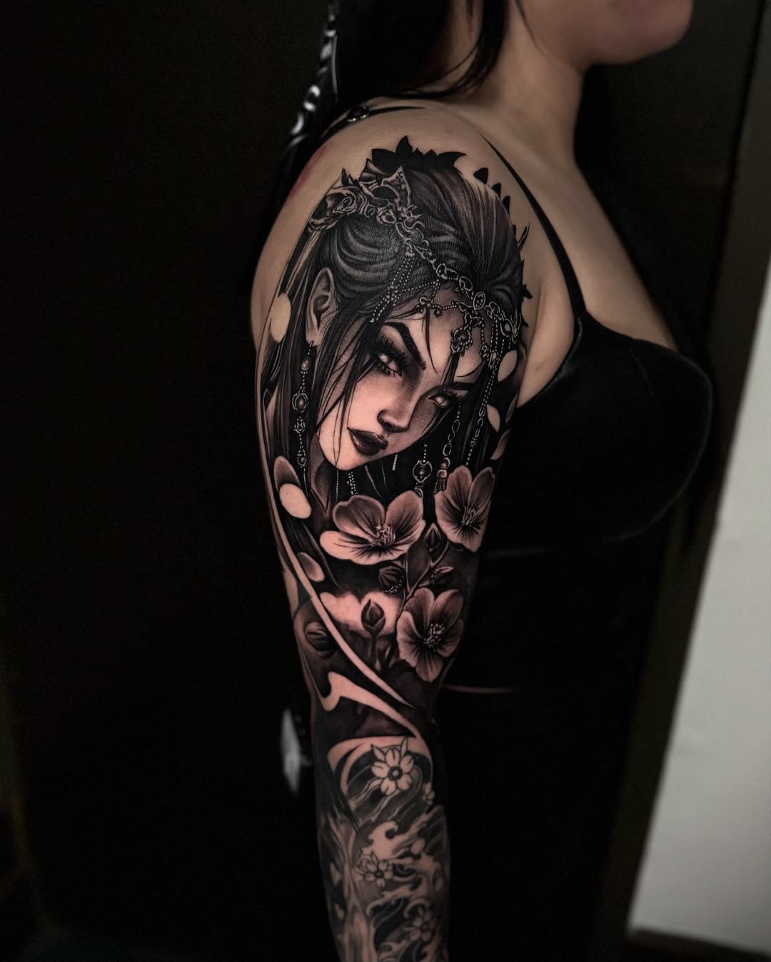 Woman with flowers realism tattoo on the upper arm by Tommy Nguyen, Eastpointe, Michigan