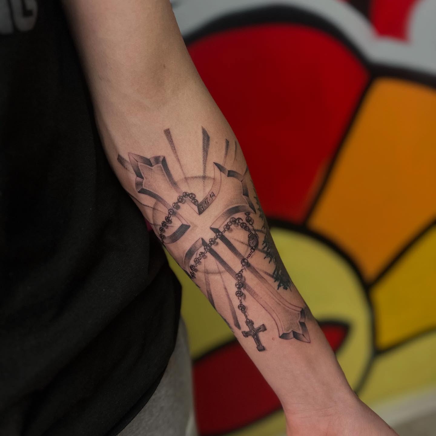 Crosses and rosary black and grey tattoo on the forearm by Antonio