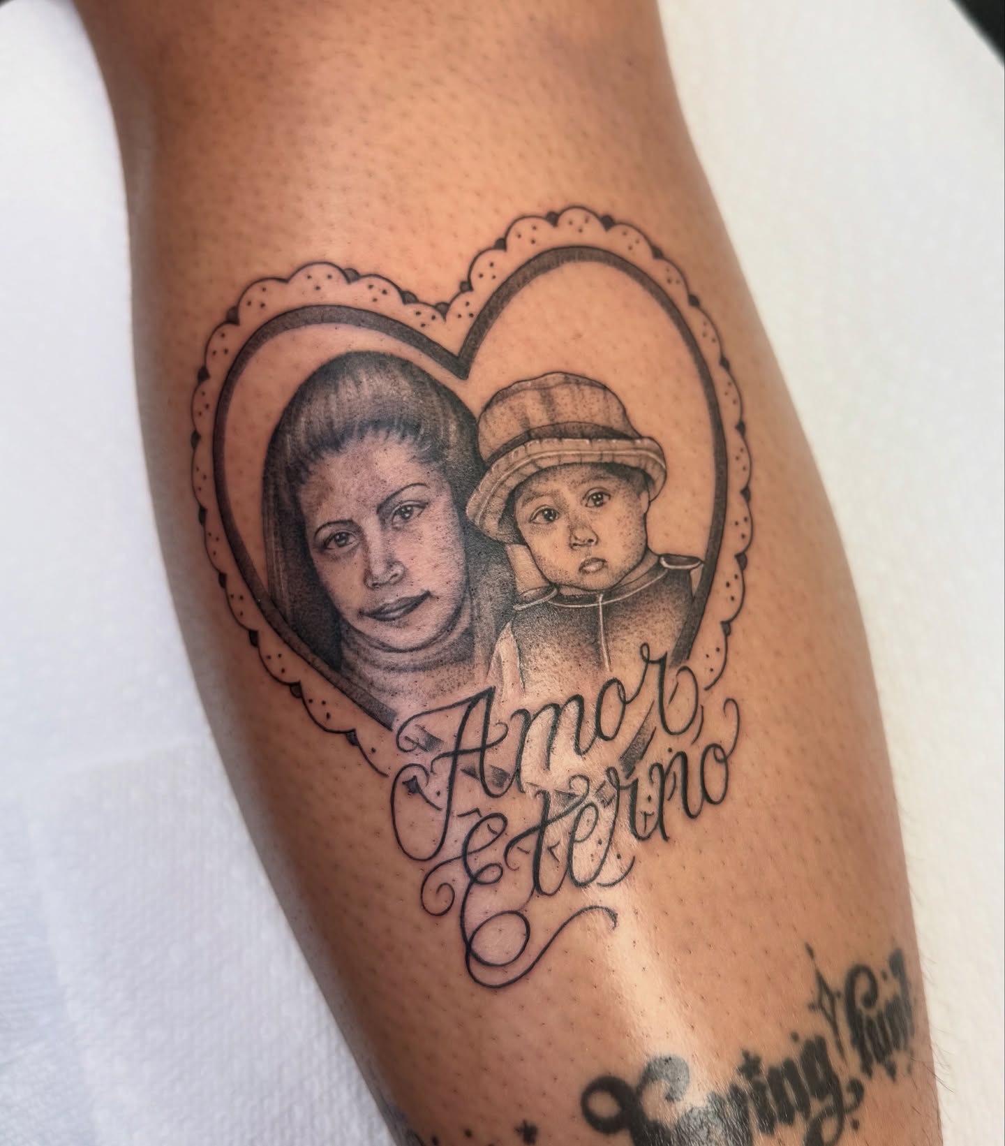 Heart with portrait black and grey tattoo on the forearm by dinah