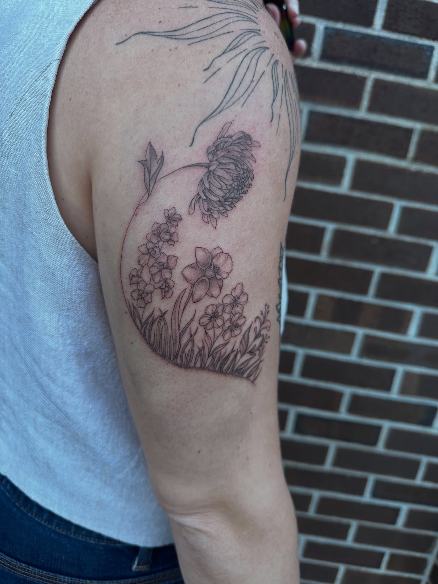 Flower bouquet black and grey tattoo on the upper arm by Hail Chaney, Somerville, Massachusetts
