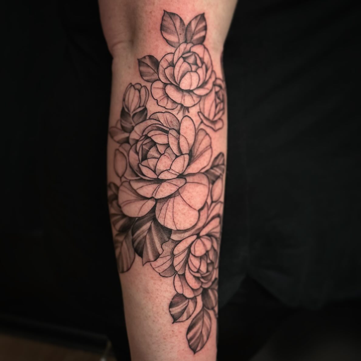 Flowers black and grey tattoo on the forearm by Sebastian Livingston