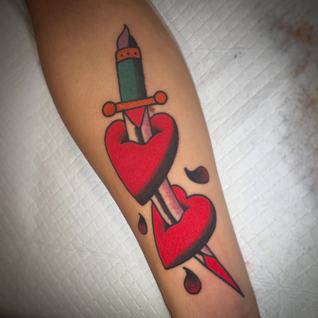 Dagger through two hearts American traditional tattoo on the forearm by Matthew Tattooer Harman