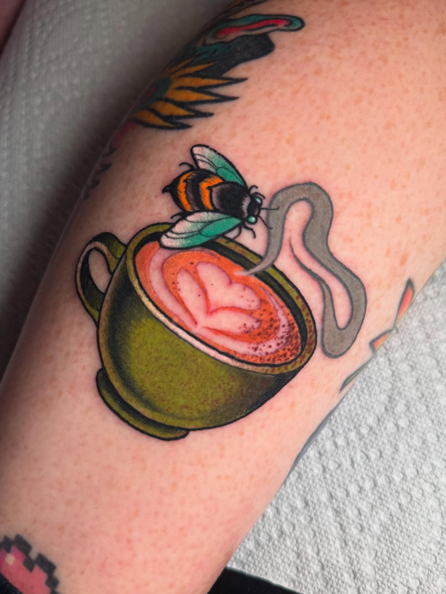 Cup of coffee with latte art American traditional tattoo on the forearm by Jess Longfield, Des Moines, Iowa